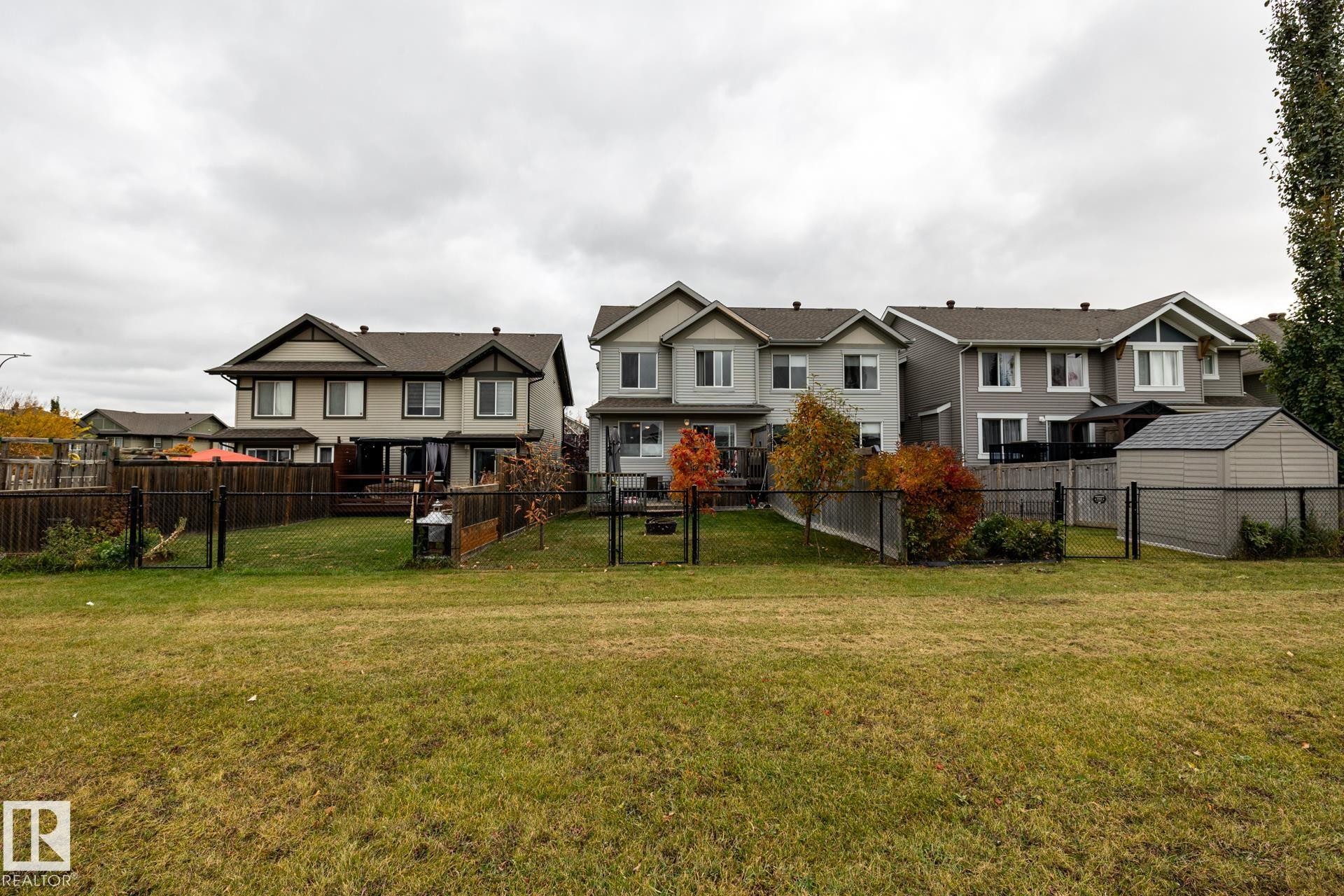 Multi-story residences featuring shingled gable roofs, siding exteriors, enclosed rear yards, and detached storage structures - 2093 Chalmers Way Sw, Edmonton, AB