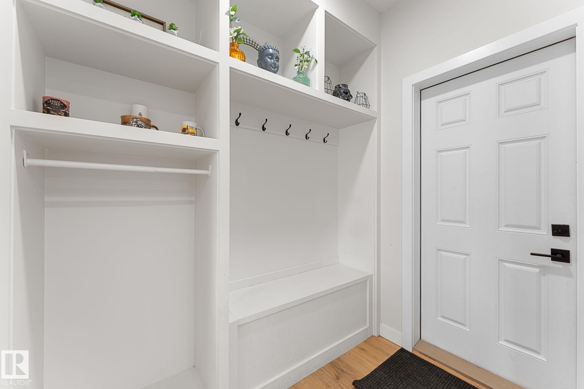 Built-in white cabinetry with a hanging rod, open shelving, and integrated bench seating - 1142 Goldfinch Crescent Nw, Edmonton, AB