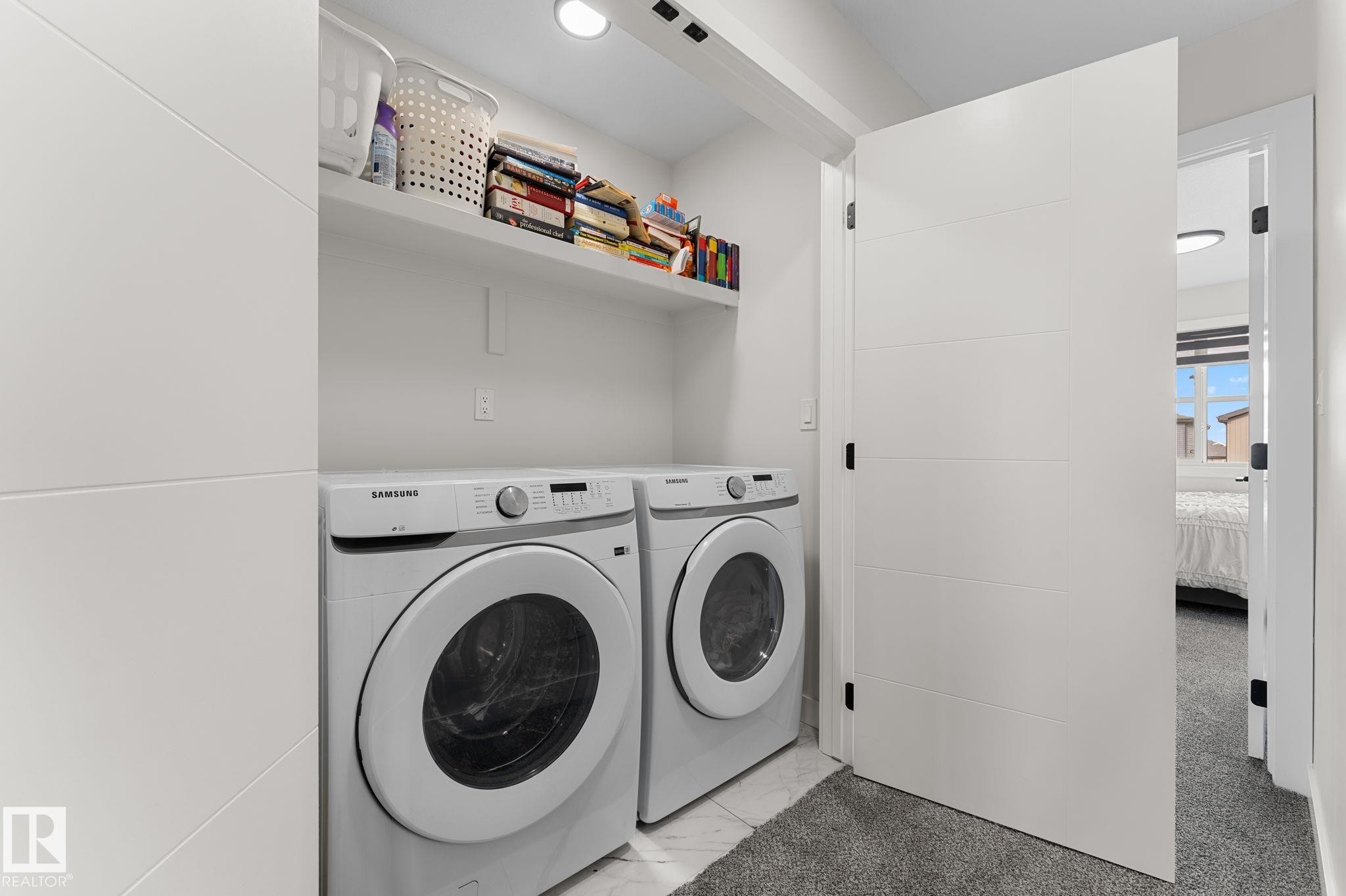 Dedicated laundry area featuring a front-load washer and dryer, integrated shelving, recessed lighting, and tile flooring - 1142 Goldfinch Crescent Nw, Edmonton, AB