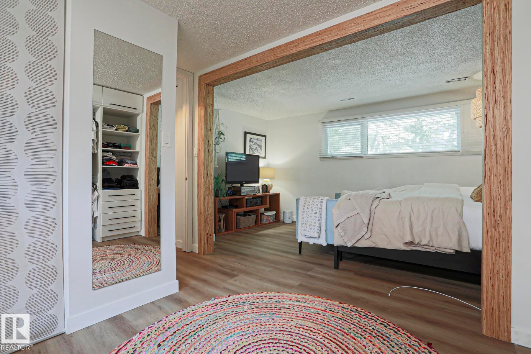Wood-finish flooring, full-length mirror, built-in closet organization, and wood-framed doorway - 5 Gilmore Crescent, St. Albert, AB