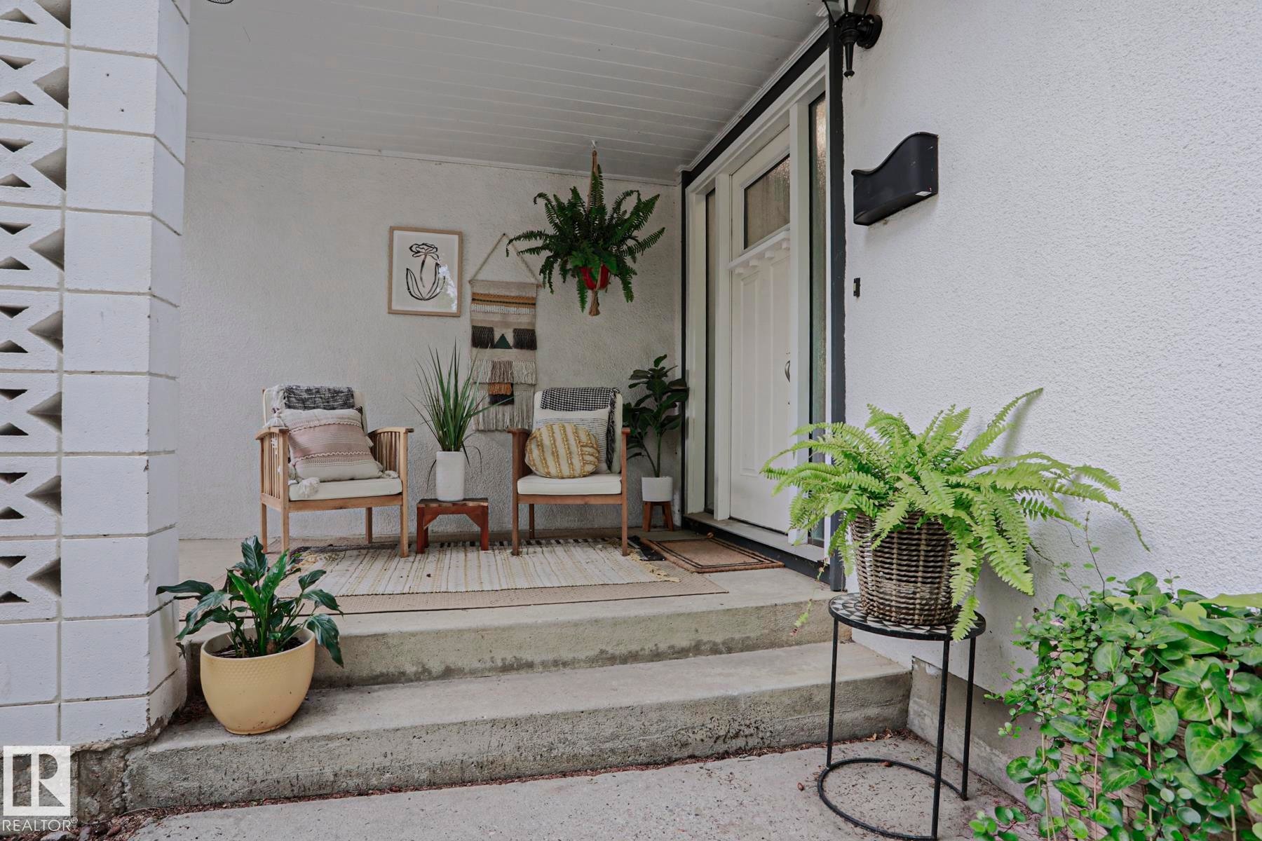 Front entry porch with concrete steps, decorative block wall, and white exterior - 5 Gilmore Crescent, St. Albert, AB