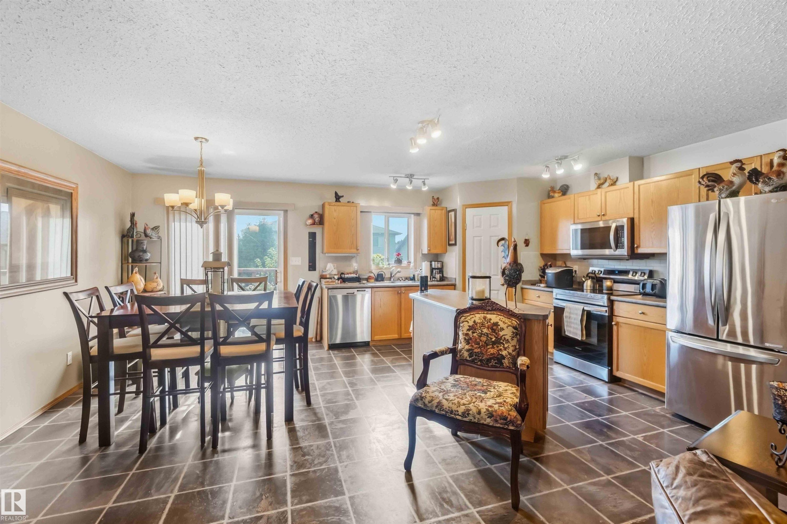Interior area featuring large-format tile flooring, a corner fireplace with stone-surround hearth, a built-in mantle, and neutral wall tones - 497 Kananaskis Drive, Devon, AB