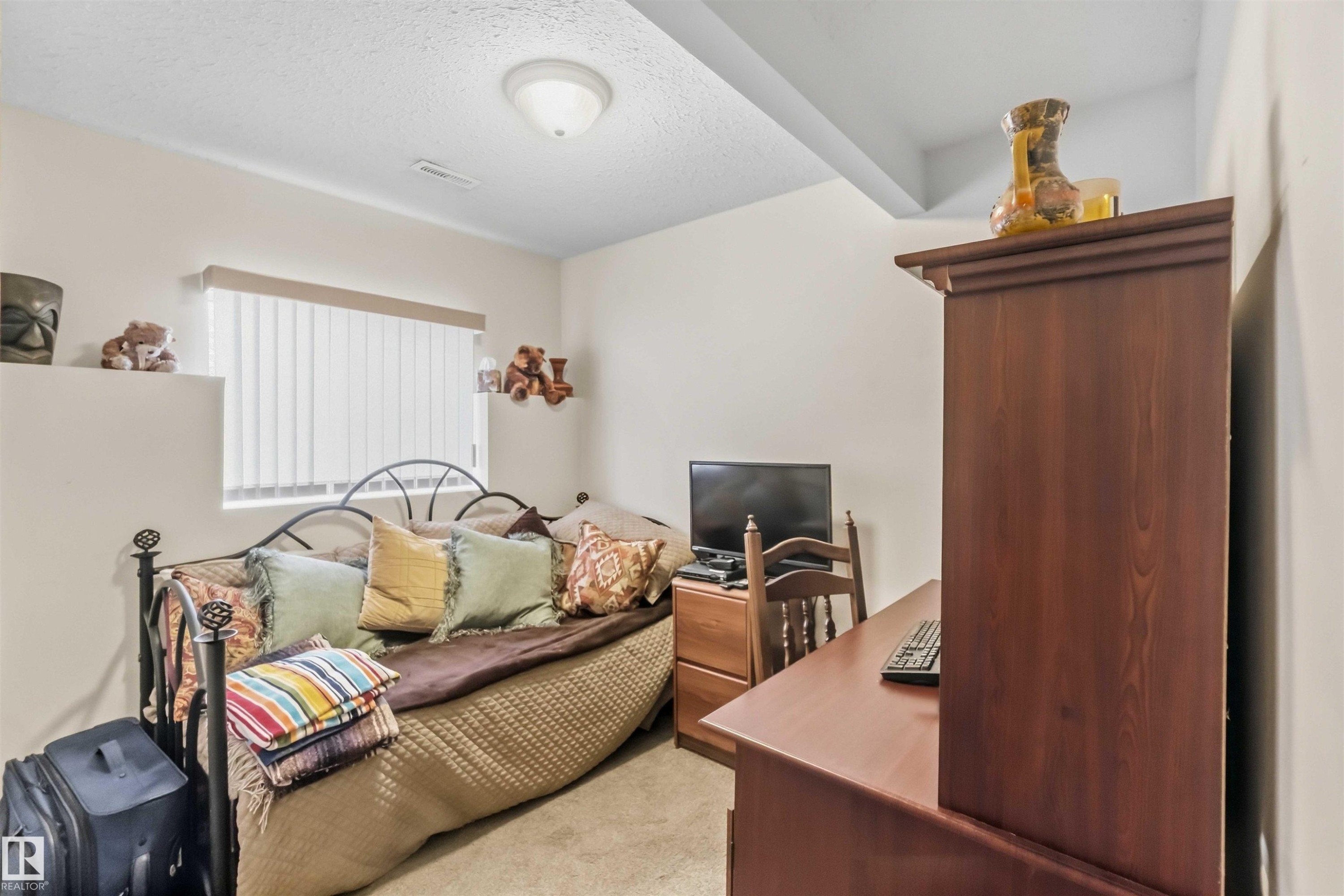 Interior space featuring carpeted staircase with a wood-finish handrail, six-panel interior door with light-colored trim, and flush-mount ceiling lighting - 497 Kananaskis Drive, Devon, AB