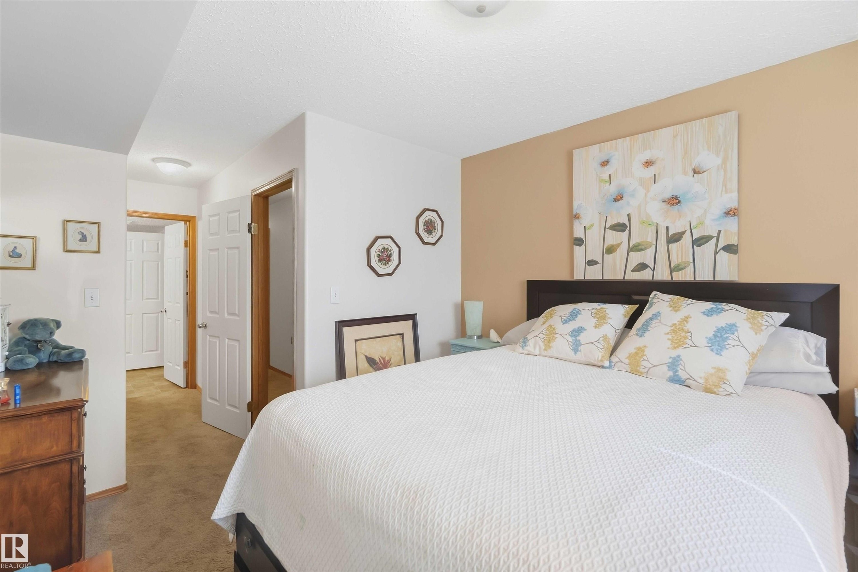 Neutral-toned room featuring a single-pane horizontal window with integrated blinds, wall-to-wall carpeting, and a flush-mount ceiling light fixture - 497 Kananaskis Drive, Devon, AB