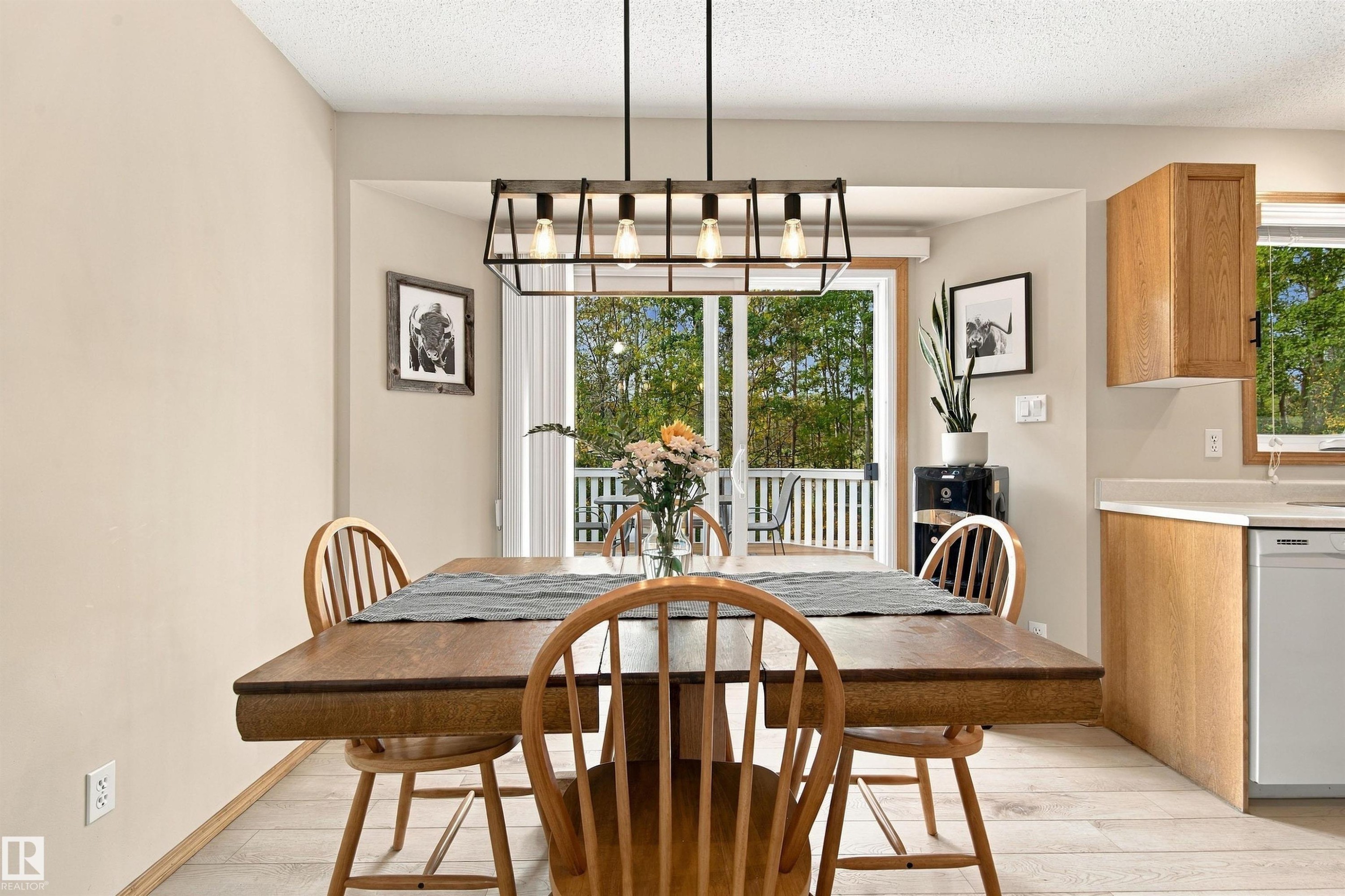 Light wood-finish flooring with a linear chandelier - 51064 Rge Rd 222, Rural Strathcona County, AB
