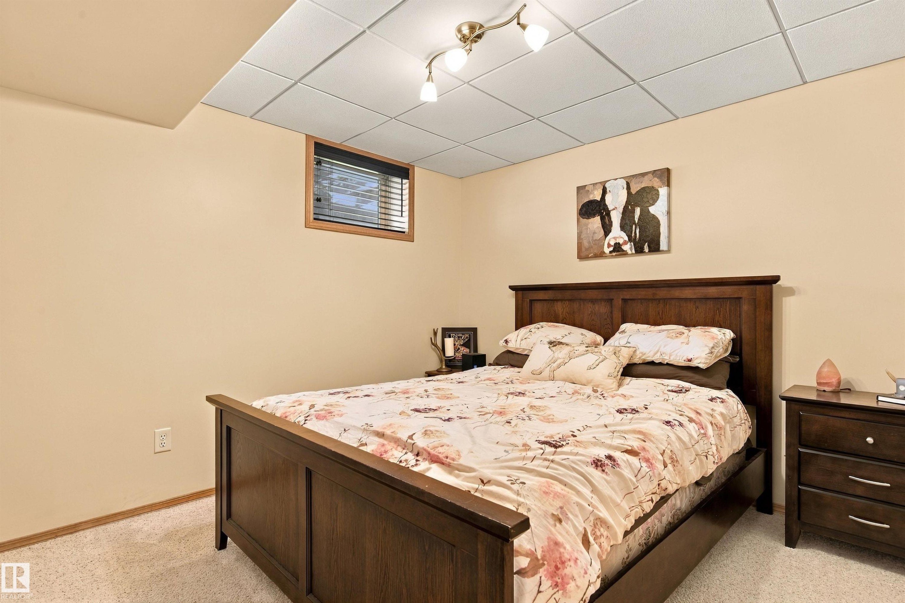 Recessed ceiling panels with track lighting, textured light-toned walls, wood-framed window with blinds, and light-toned carpet flooring - 51064 Rge Rd 222, Rural Strathcona County, AB