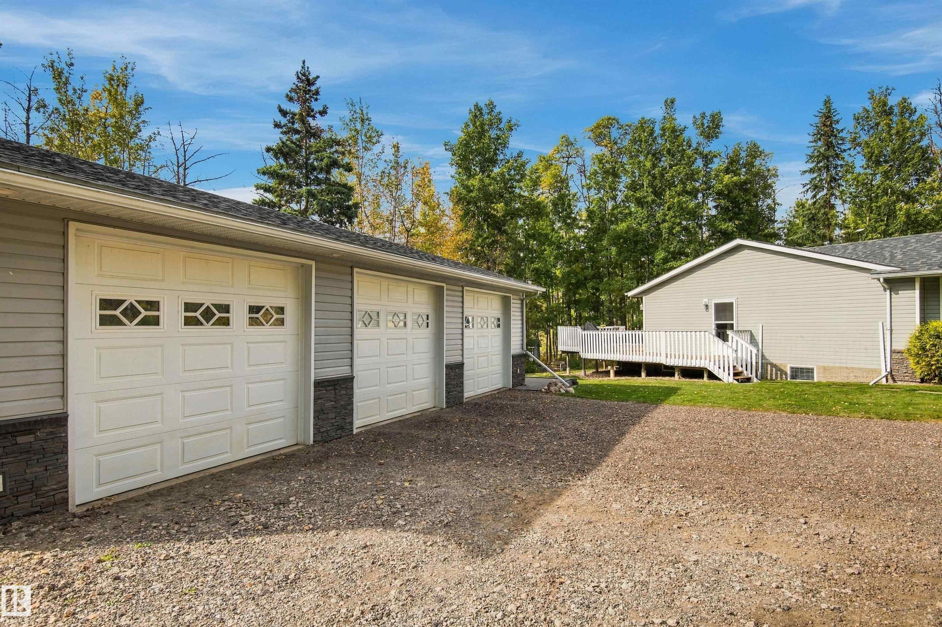 Three-car garage with panel doors and decorative window inserts - 51064 Rge Rd 222, Rural Strathcona County, AB