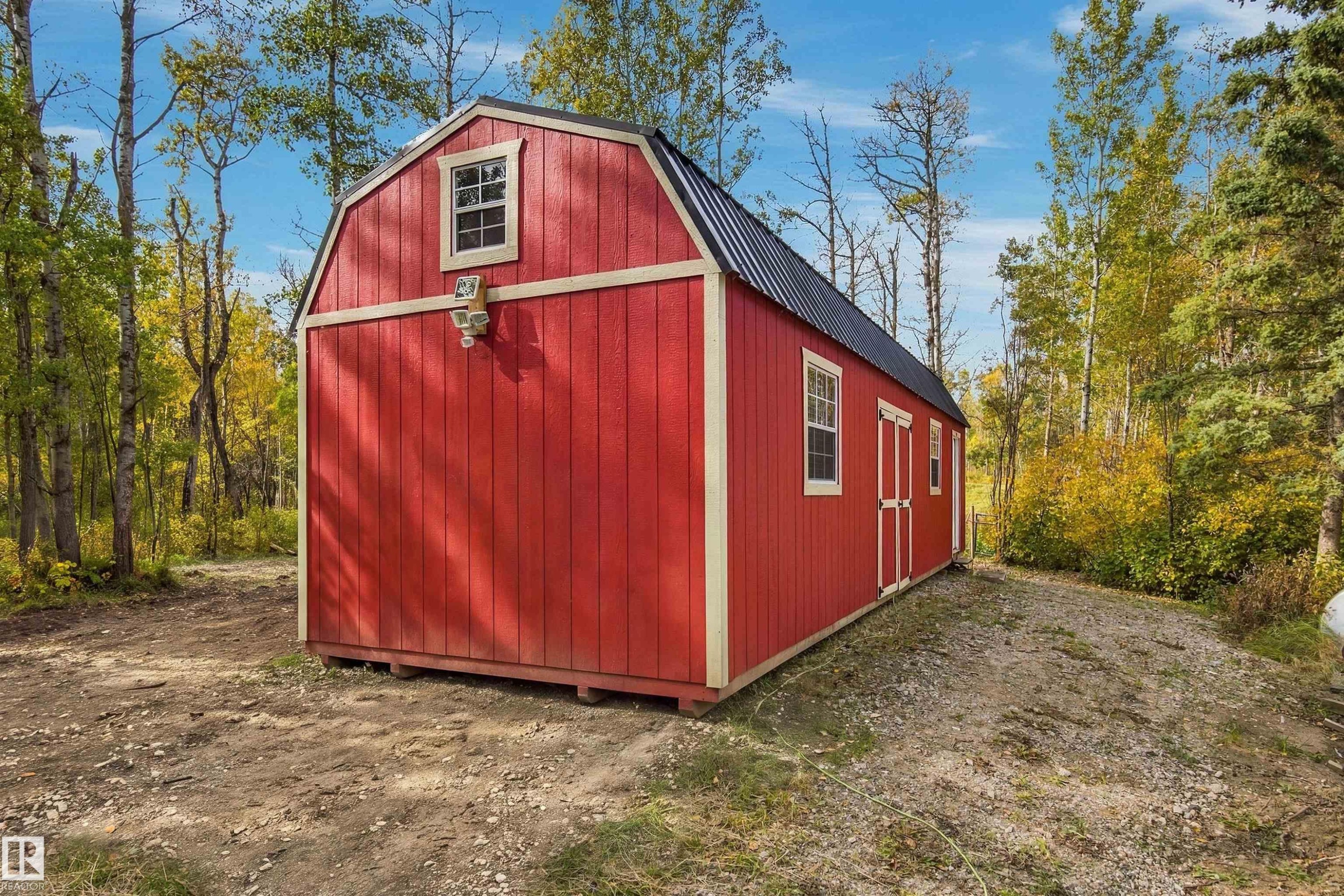 Red vertical siding with white trim, black metal roof, and upper-level window - 51064 Rge Rd 222, Rural Strathcona County, AB