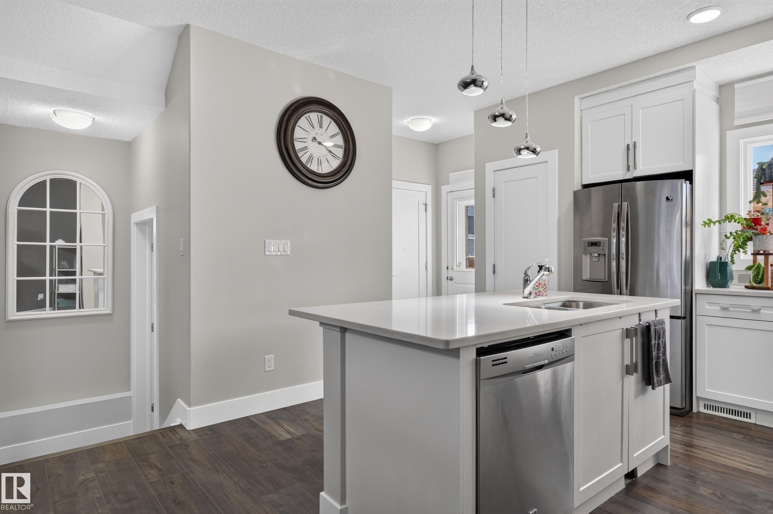 Kitchen island featuring stone countertops, an undermount sink, and integrated stainless steel dishwasher - 798 Berg Loop, Leduc, AB