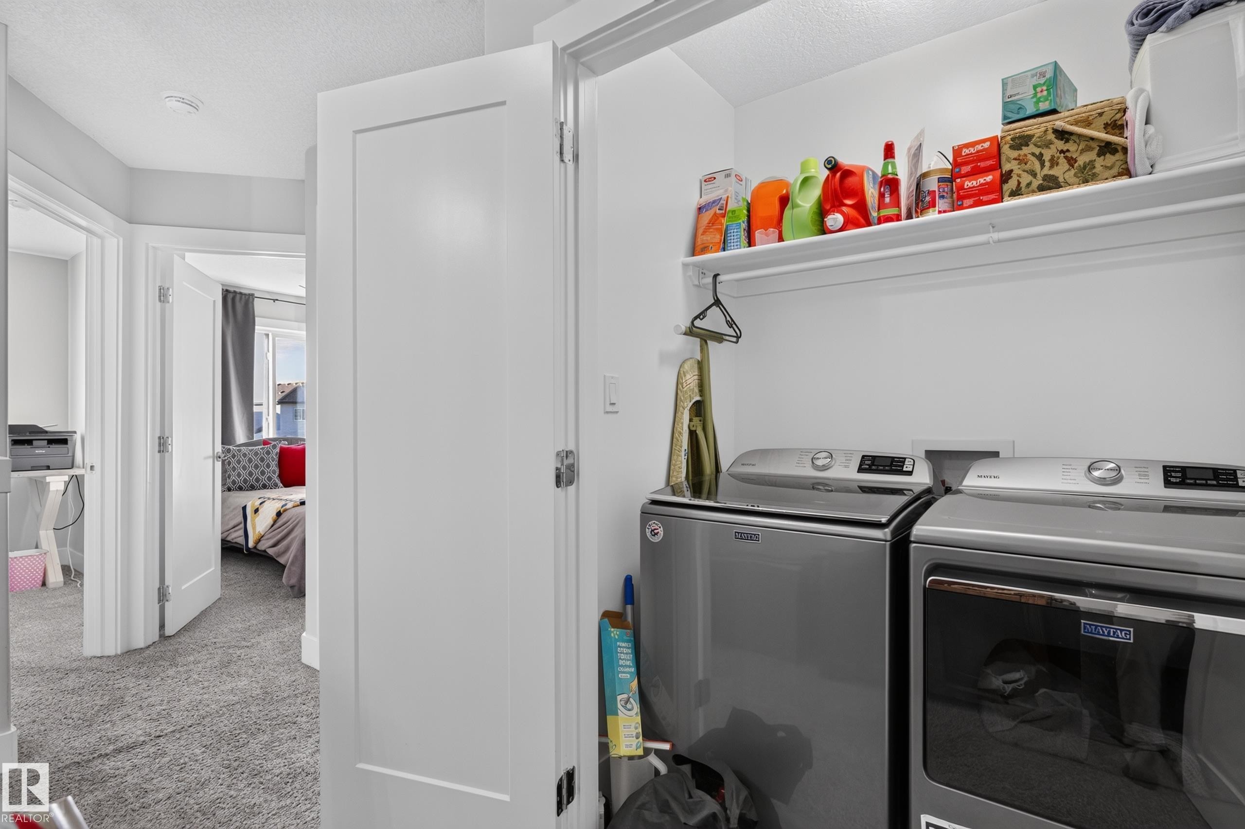Laundry alcove featuring stainless steel laundry appliances and a built-in overhead storage shelf - 798 Berg Loop, Leduc, AB