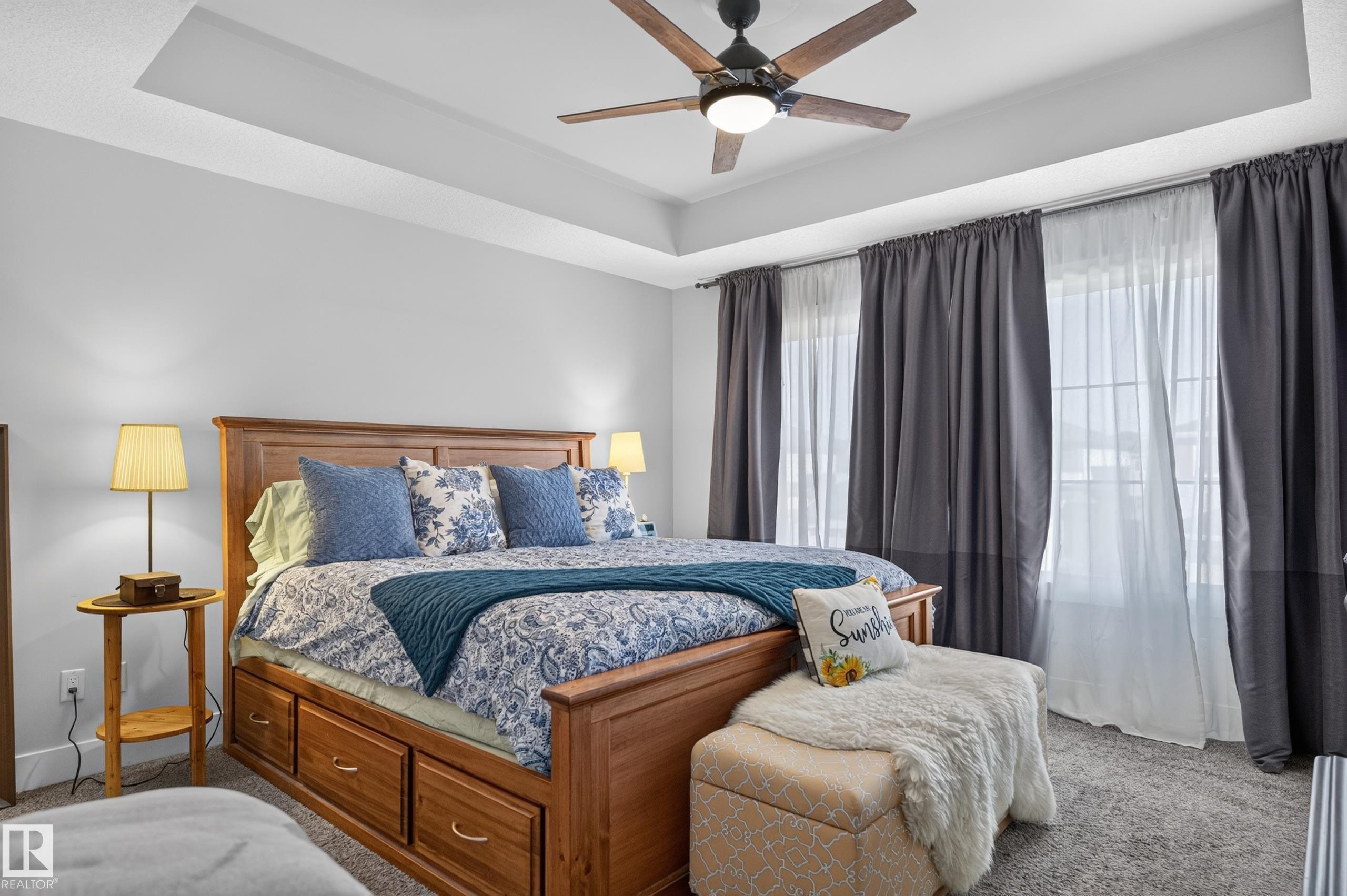 Tray ceiling featuring a central five-blade ceiling fan with integrated lighting and multi-pane windows - 798 Berg Loop, Leduc, AB
