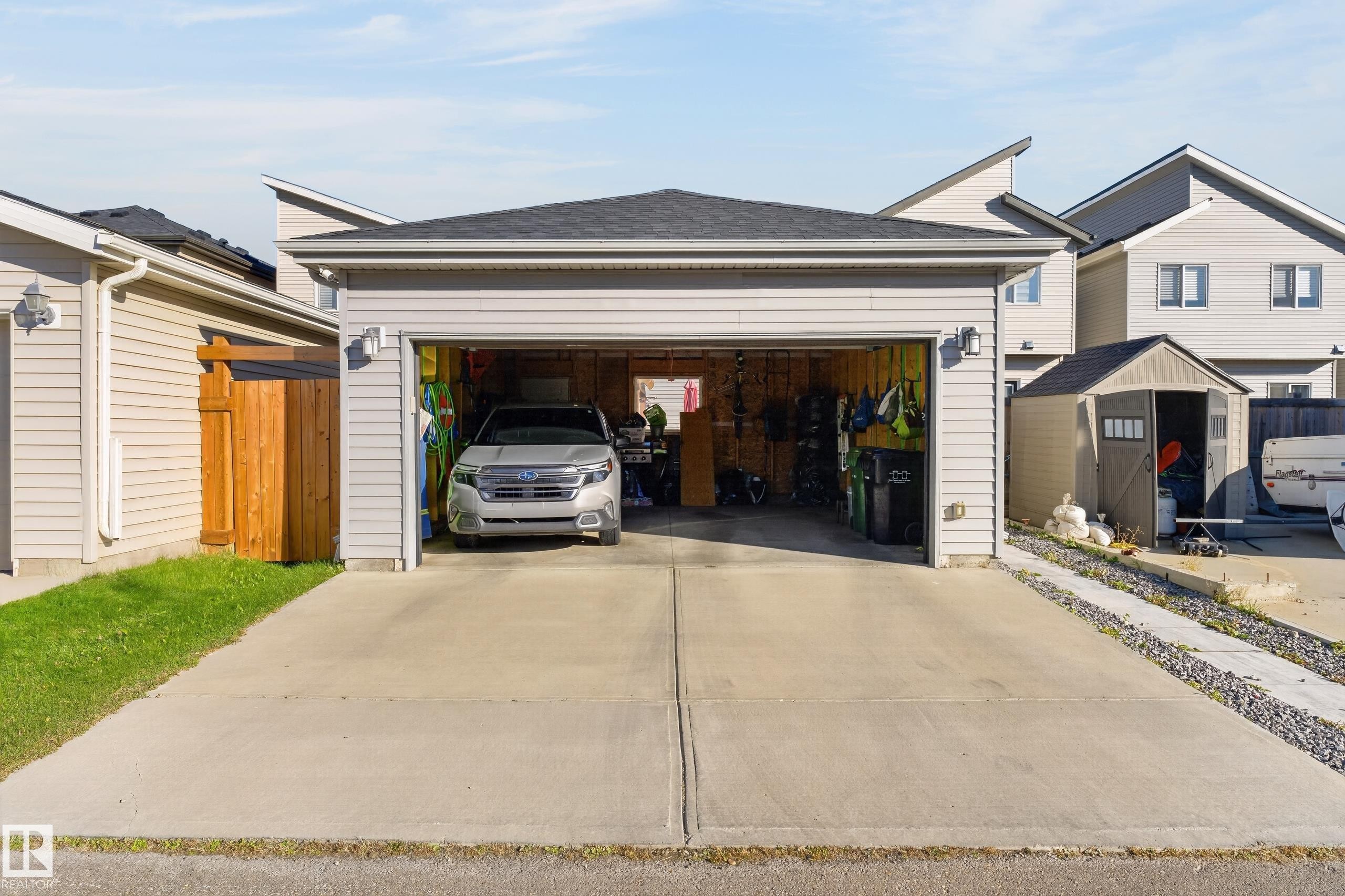 Detached garage featuring vinyl siding, asphalt shingle roofing, and a concrete driveway - 798 Berg Loop, Leduc, AB