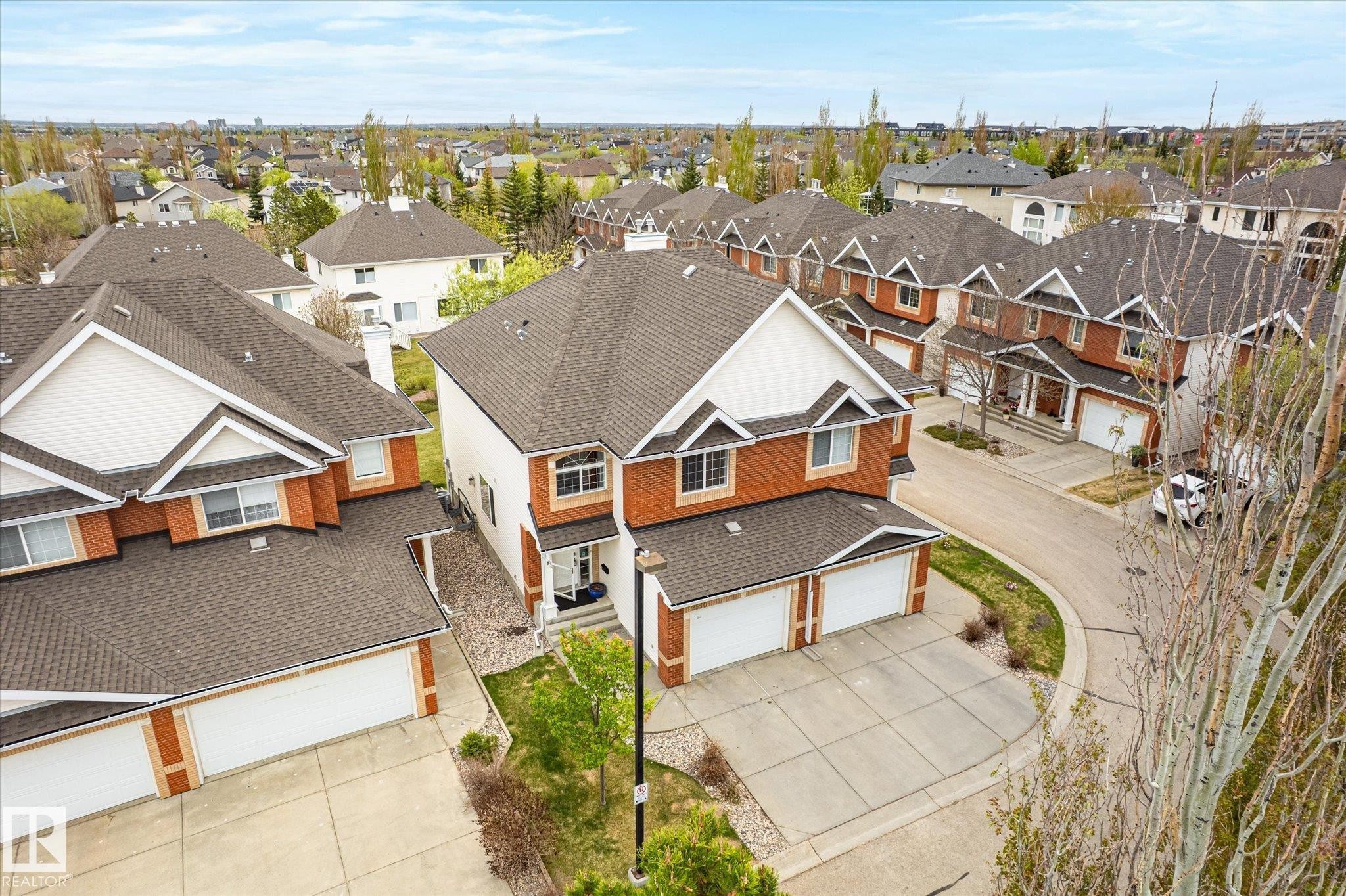 Brick exterior with white siding accents and a pitched asphalt shingle roof - 2550 Rabbit Hill Road Nw, Edmonton, AB
