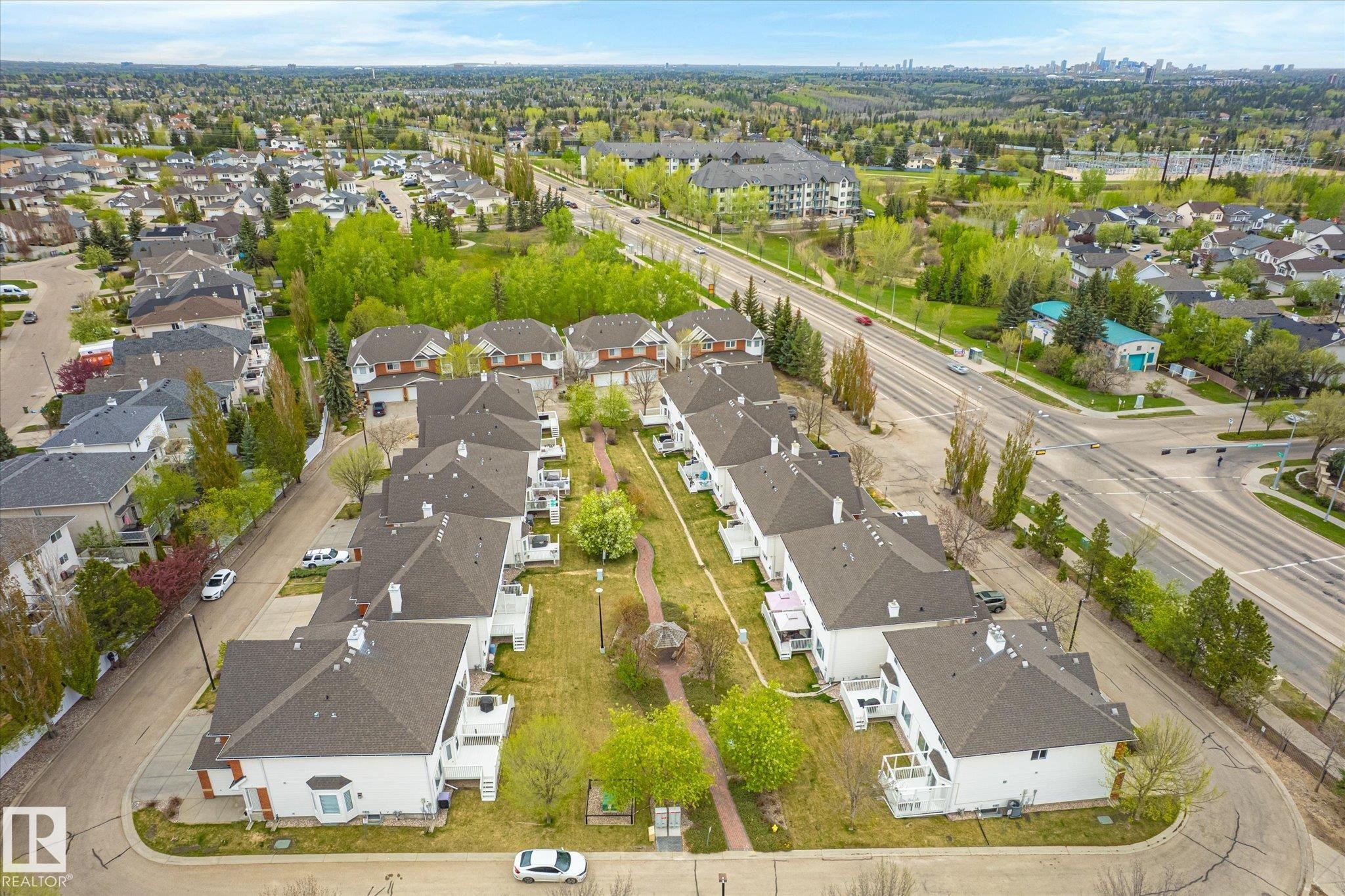 Aerial perspective of a neighborhood featuring multiple residential structures, mature trees, and paved roadways - 2550 Rabbit Hill Road Nw, Edmonton, AB