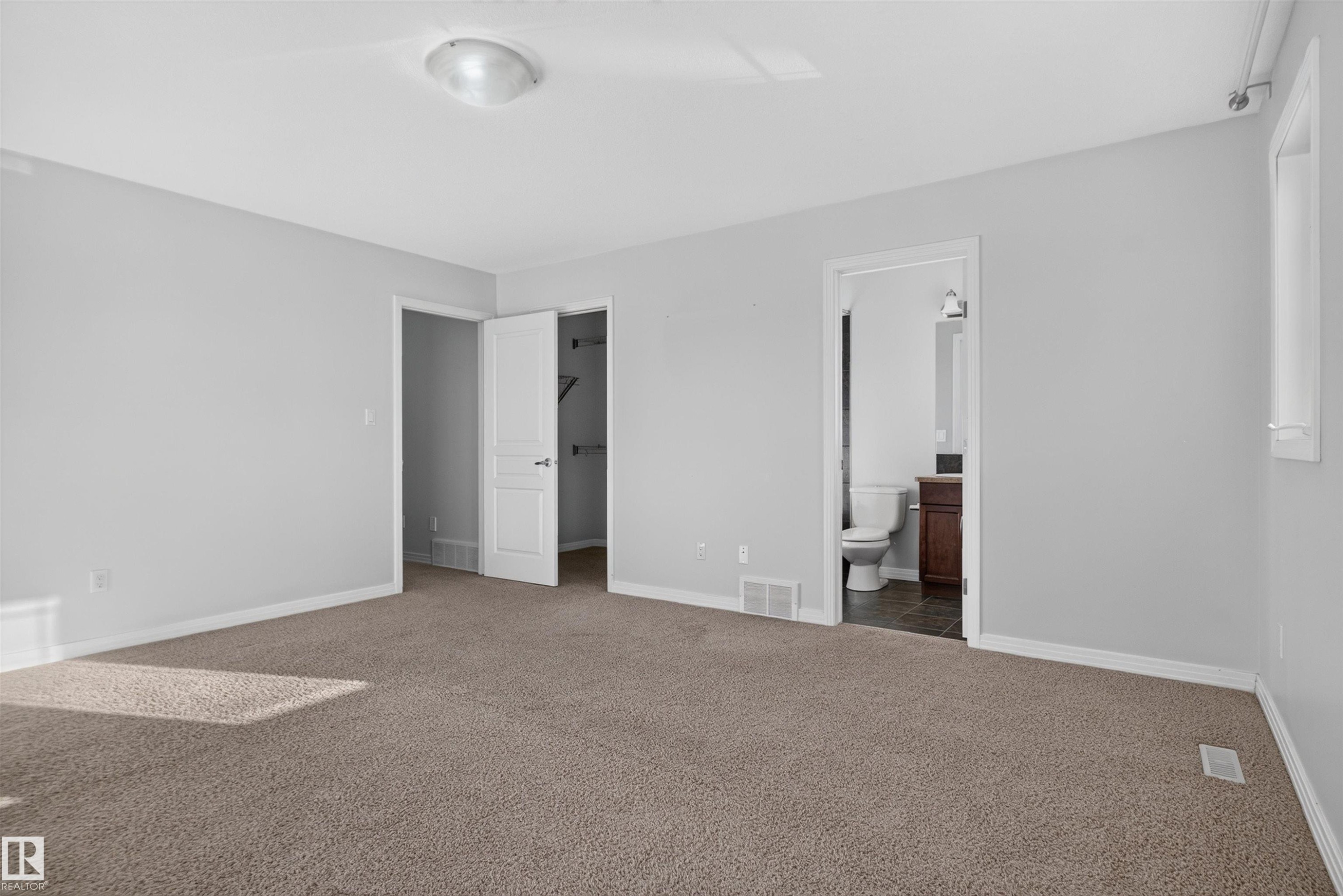 Light gray painted walls with brown carpet flooring - 2145 28 Street Nw, Edmonton, AB