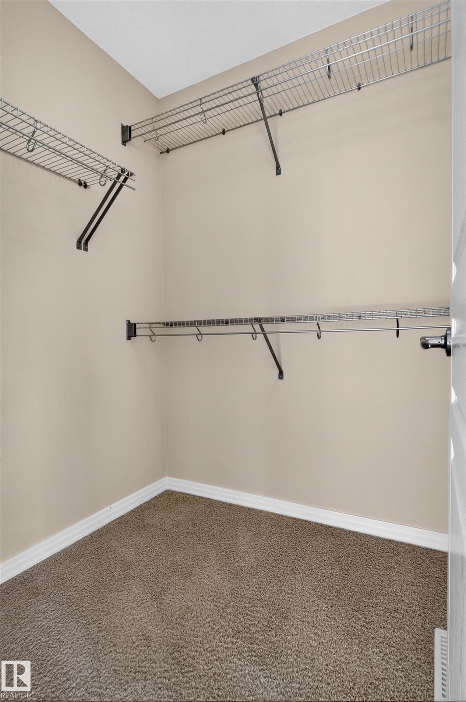 Walk-in closet with wire shelving, integrated hanging rods, and carpet flooring - 2145 28 Street Nw, Edmonton, AB