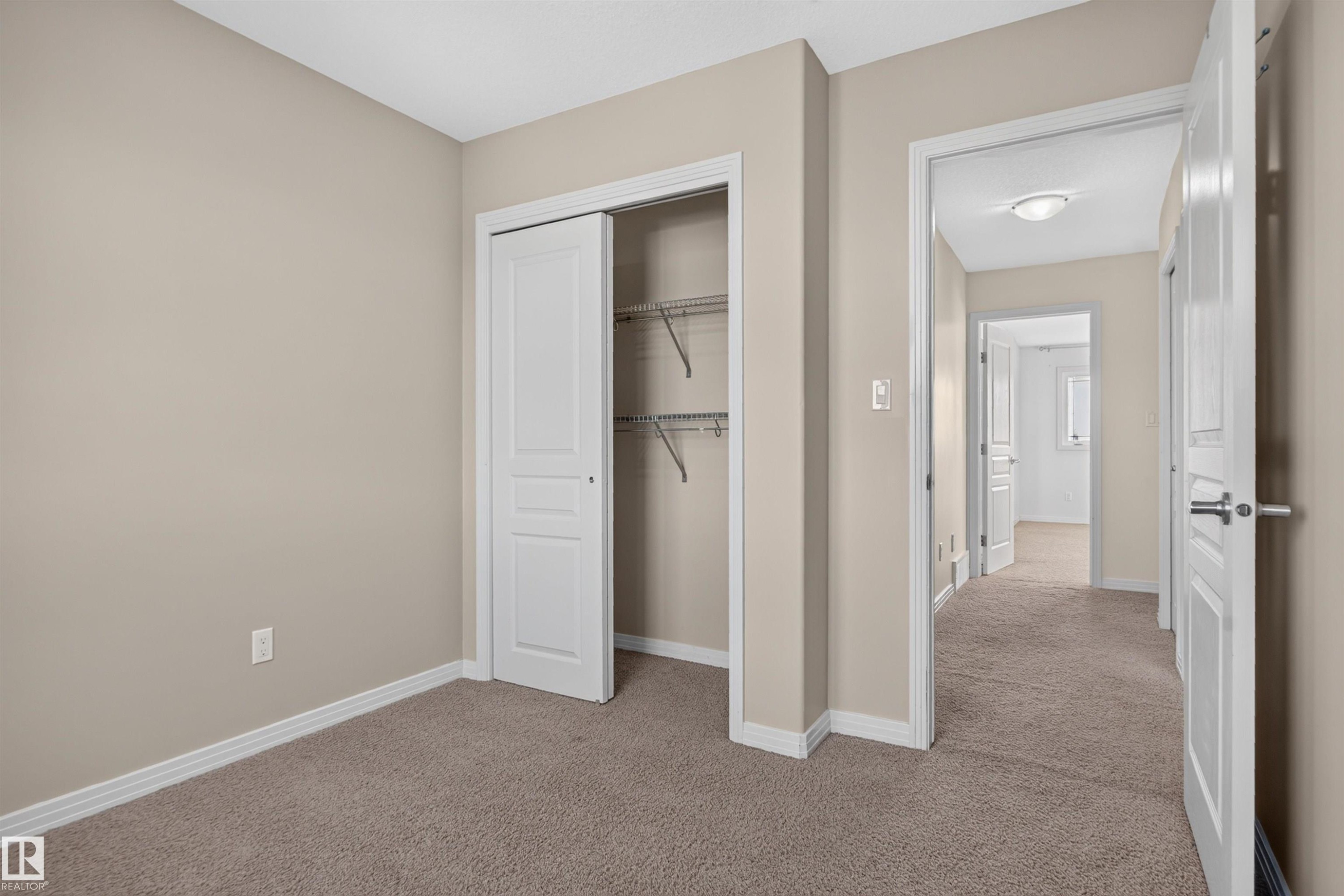 Neutral-toned walls complement plush carpet flooring - 2145 28 Street Nw, Edmonton, AB