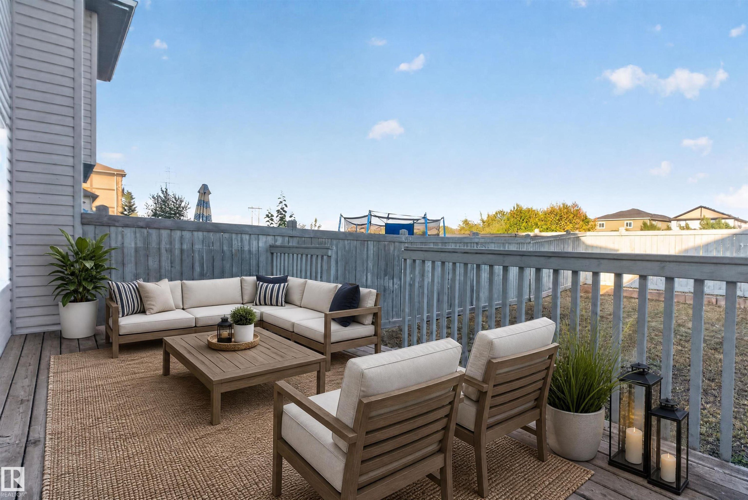 Expansive wood deck with a full-height privacy fence and painted railing - 2145 28 Street Nw, Edmonton, AB
