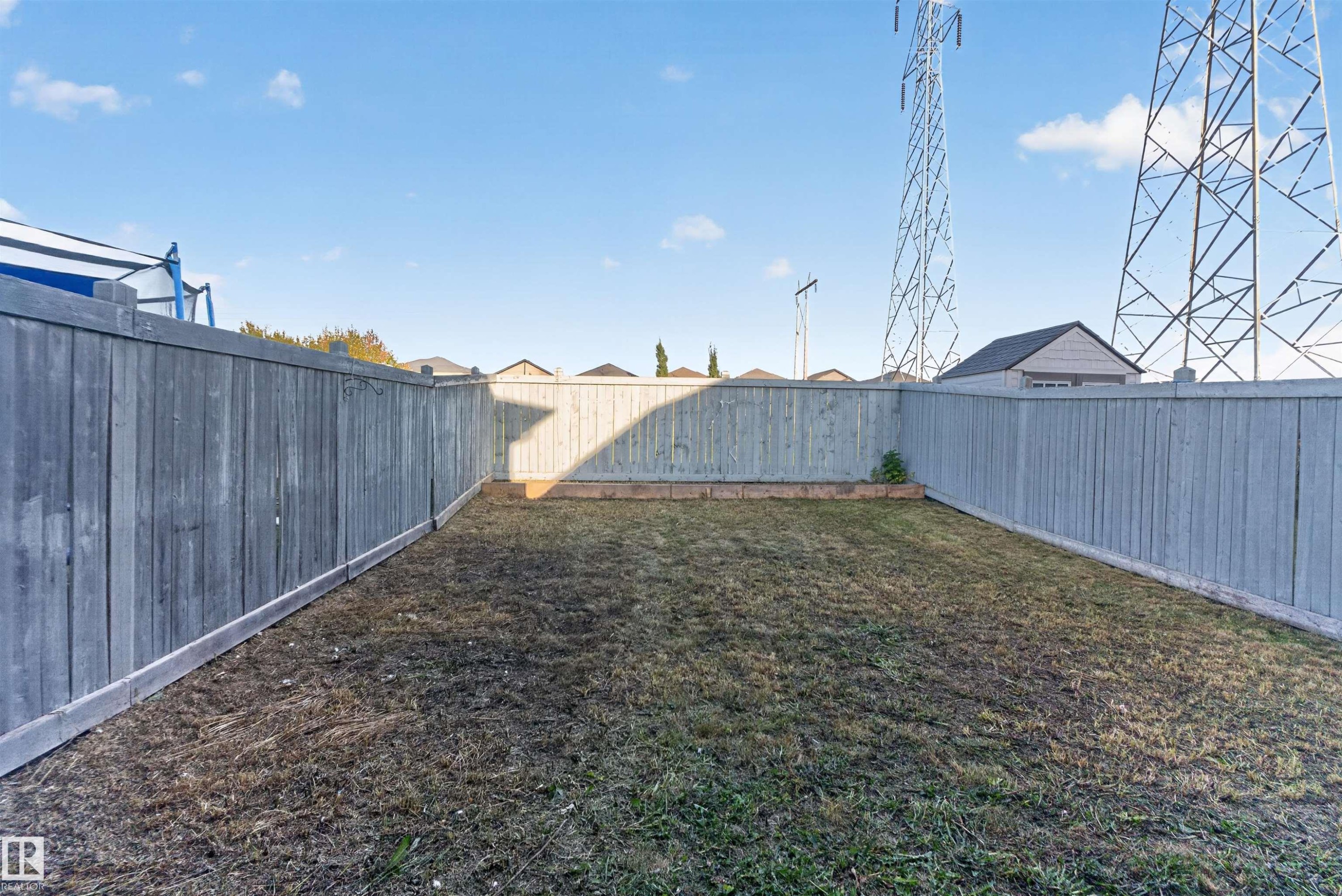 Fenced backyard with wood privacy fencing and a raised garden bed - 2145 28 Street Nw, Edmonton, AB