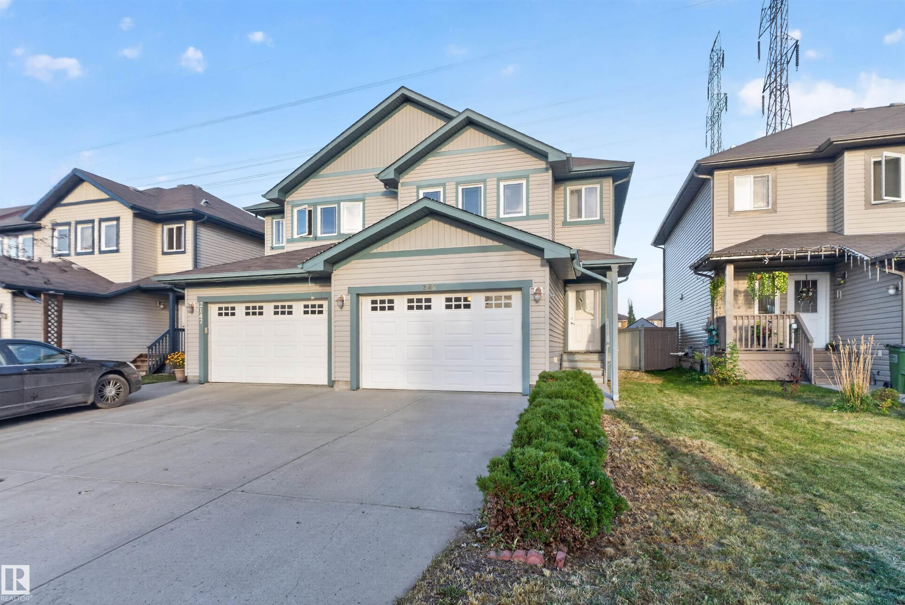 Two-story home with light-colored siding, a dark roof, and a two-car garage - 2145 28 Street Nw, Edmonton, AB