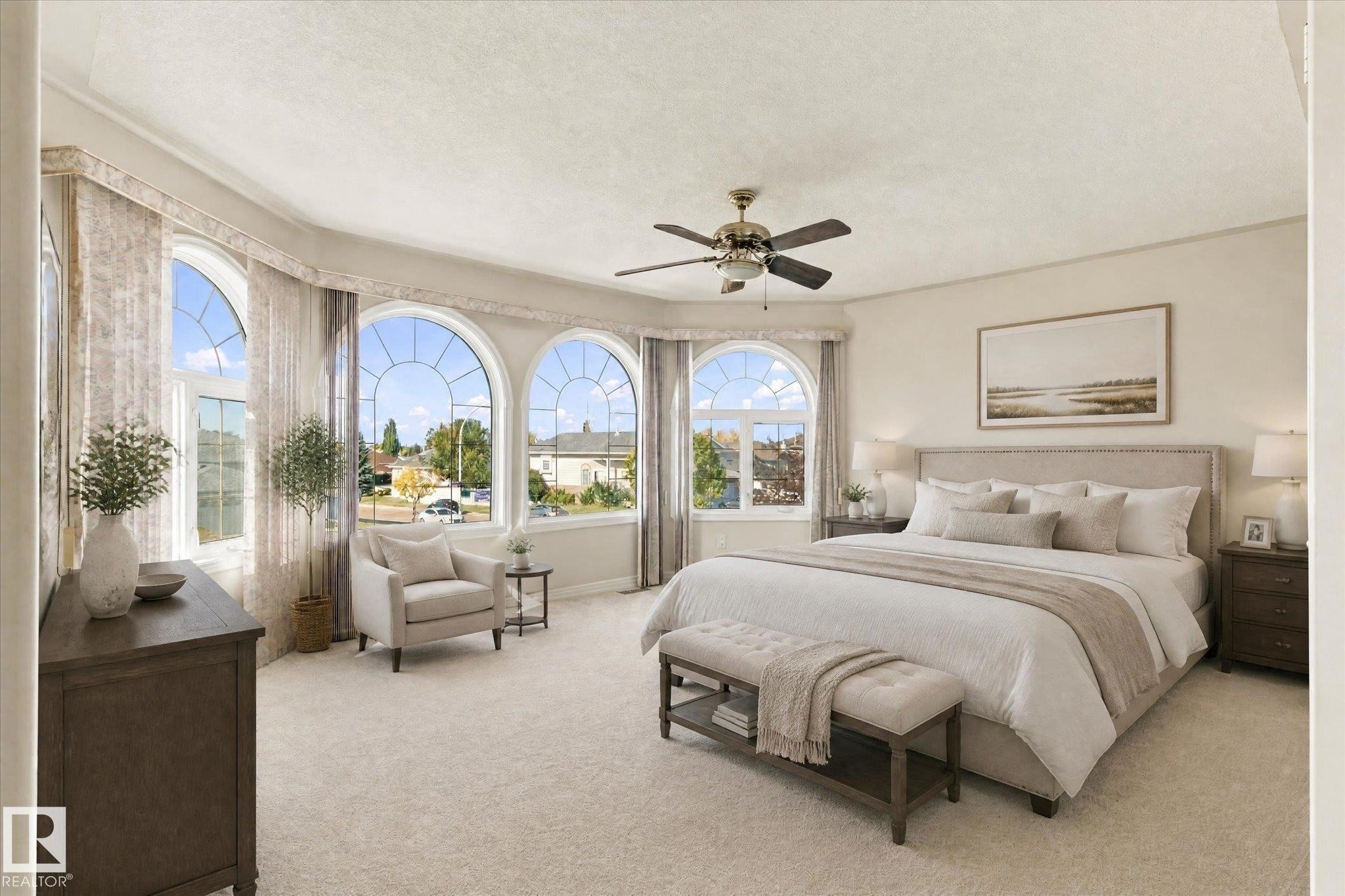 Arched bay windows with decorative grilles, ceiling fan with light fixture, light-toned carpeting, and neutral wall tones - 771 Johns Road Nw, Edmonton, AB