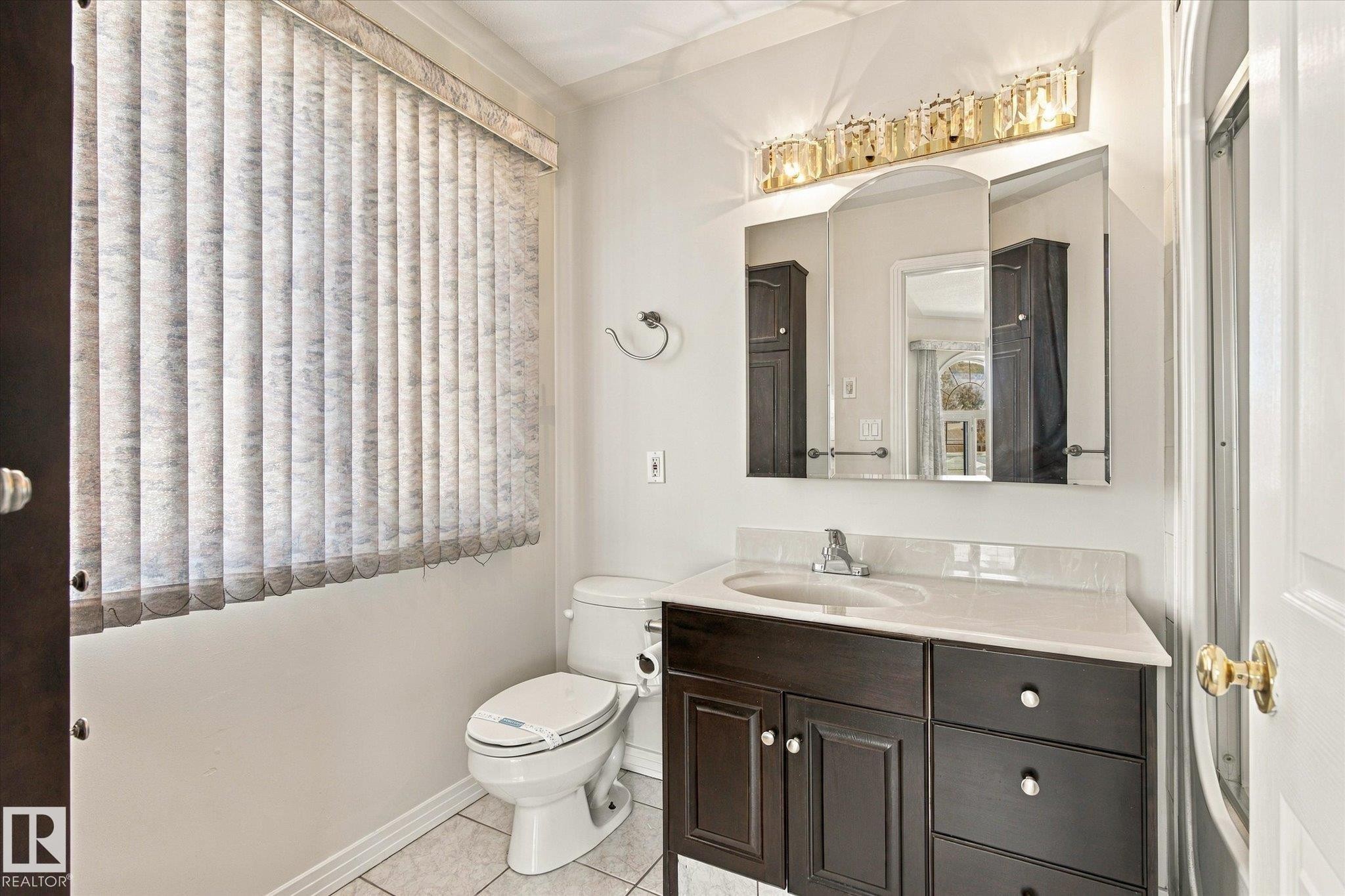 Vanity with a light-colored countertop, recessed sink, and dark wood-finish cabinetry - 771 Johns Road Nw, Edmonton, AB