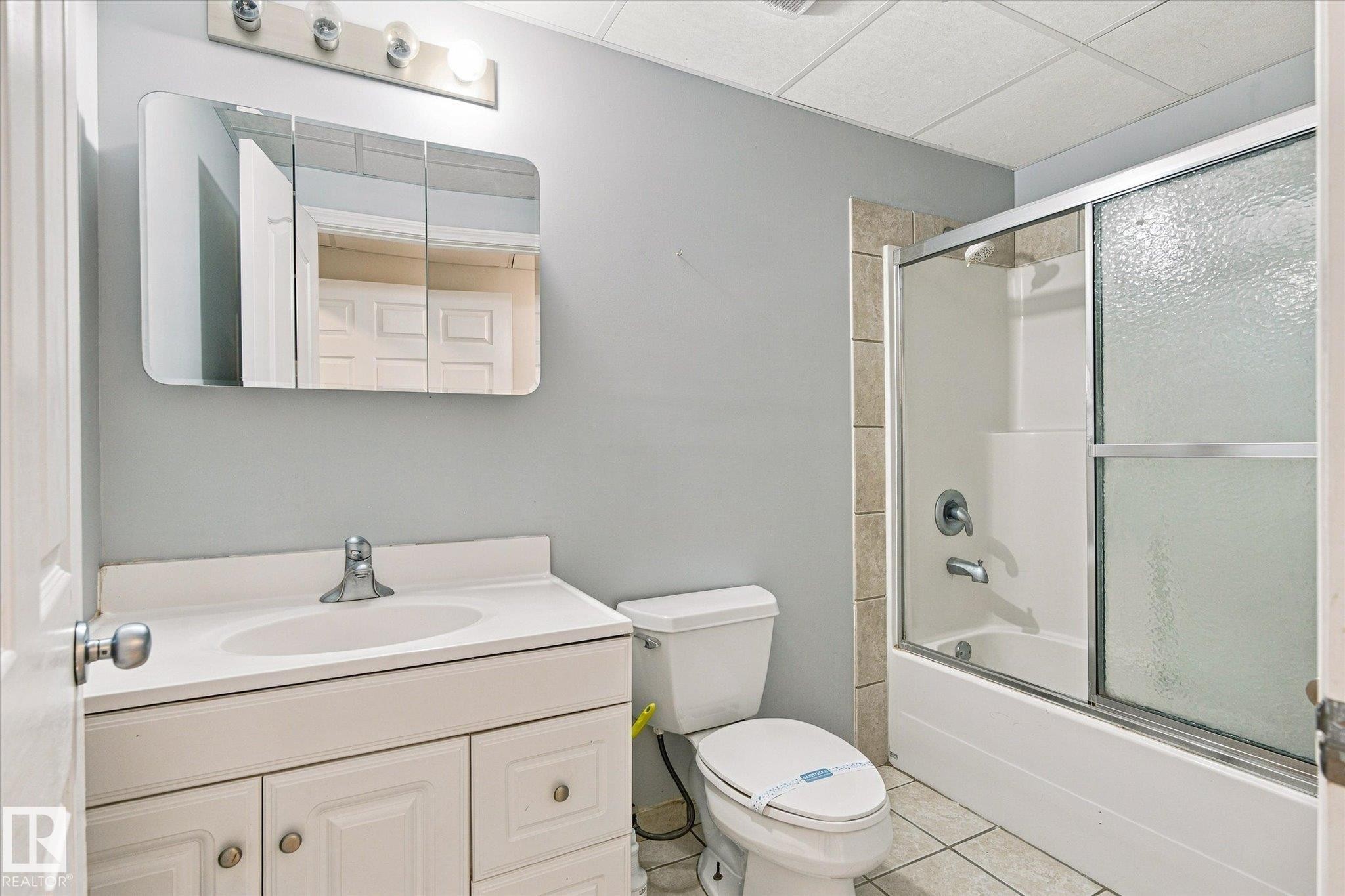 White vanity with integrated sink, chrome faucet, and mirrored medicine cabinet - 771 Johns Road Nw, Edmonton, AB