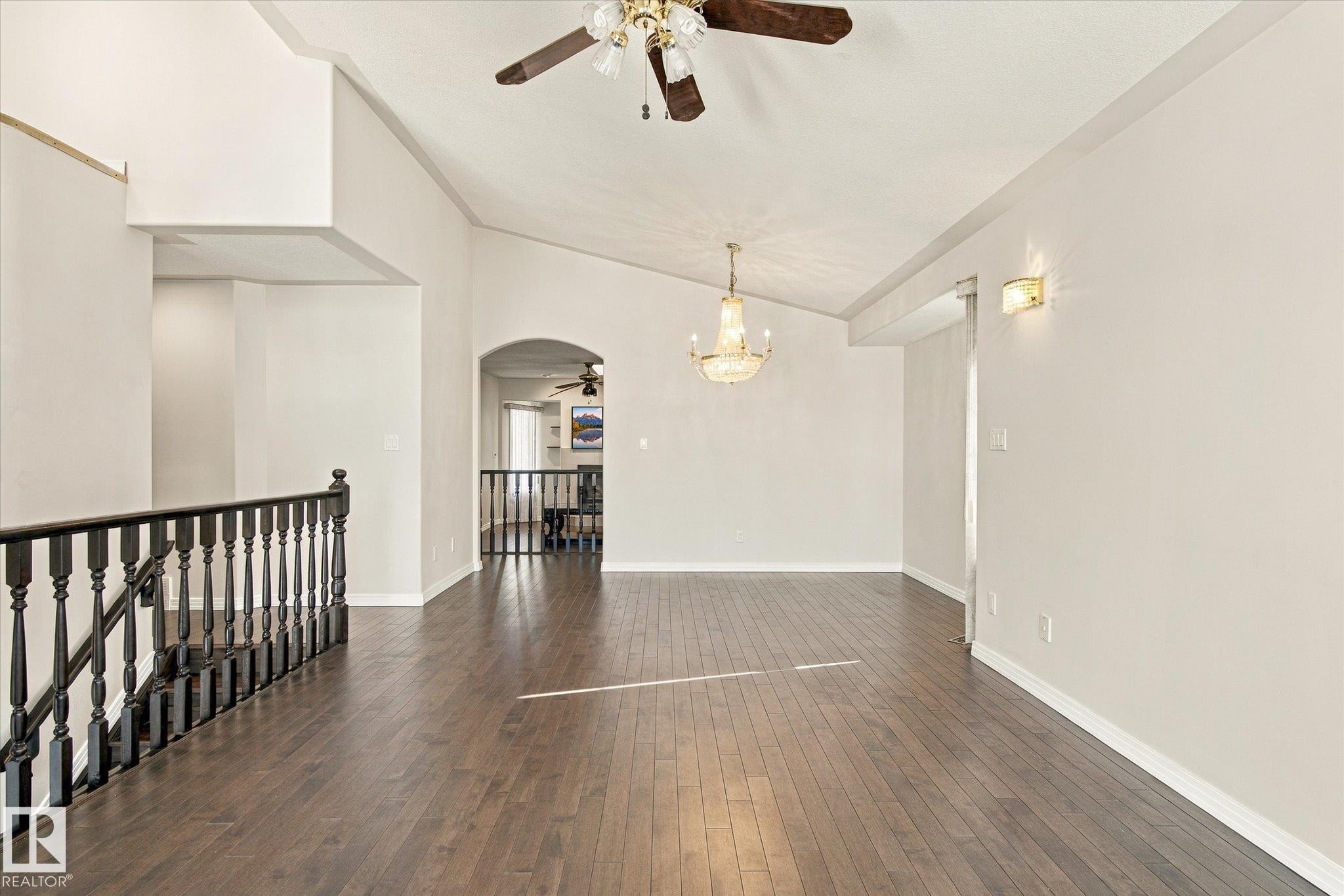 Vaulted ceilings, wood-finish flooring, chandelier, ceiling fan, and staircase with dark wood banister - 771 Johns Road Nw, Edmonton, AB