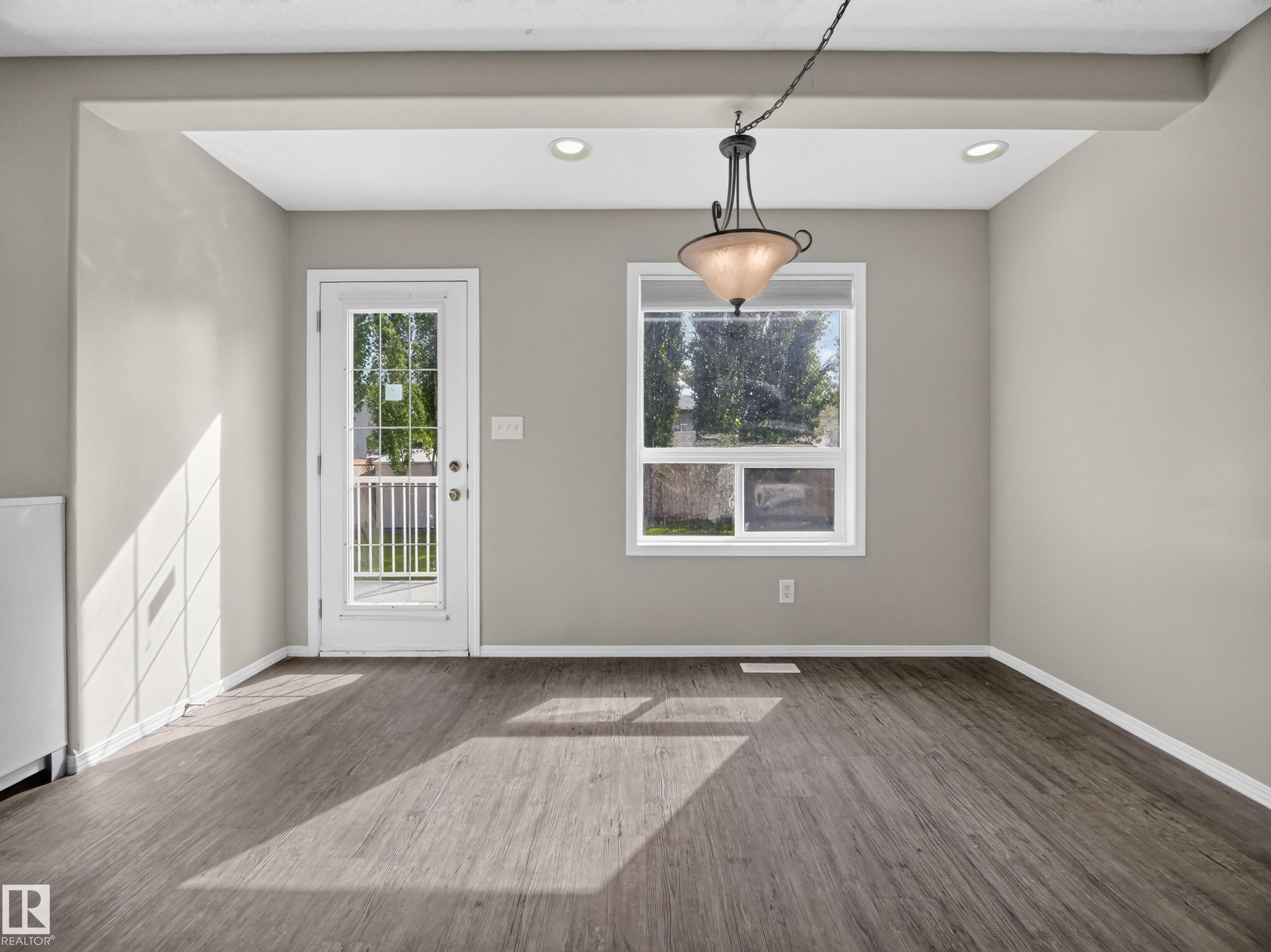 Wood-finish flooring, recessed lighting, and a hanging light fixture - 14 Wells Court, Leduc, AB
