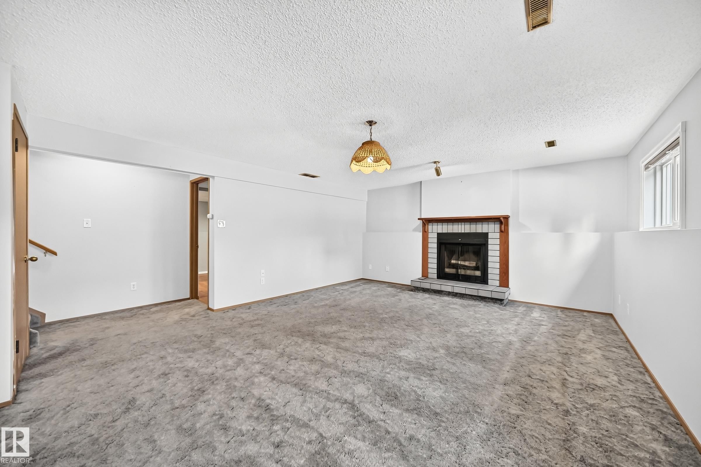 Spacious living room featuring neutral carpet flooring, white walls, and recessed lighting - 14519 32 Street Nw, Edmonton, AB