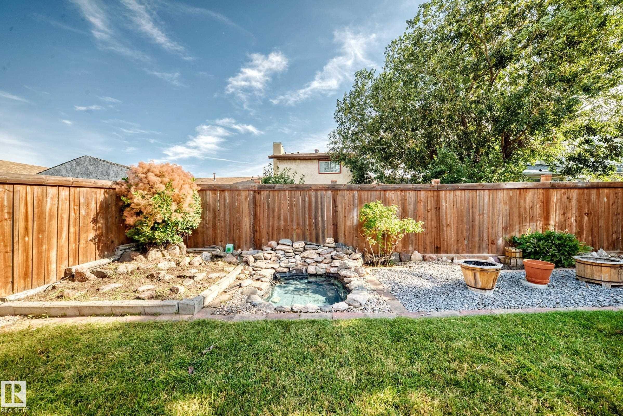 Manicured lawn with a wood fence perimeter - 14519 32 Street Nw, Edmonton, AB