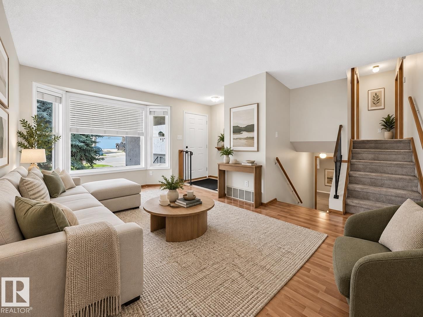 Hardwood-style flooring, expansive bay window, front entry door, staircase with wood railing, and recessed lighting - 14519 32 Street Nw, Edmonton, AB
