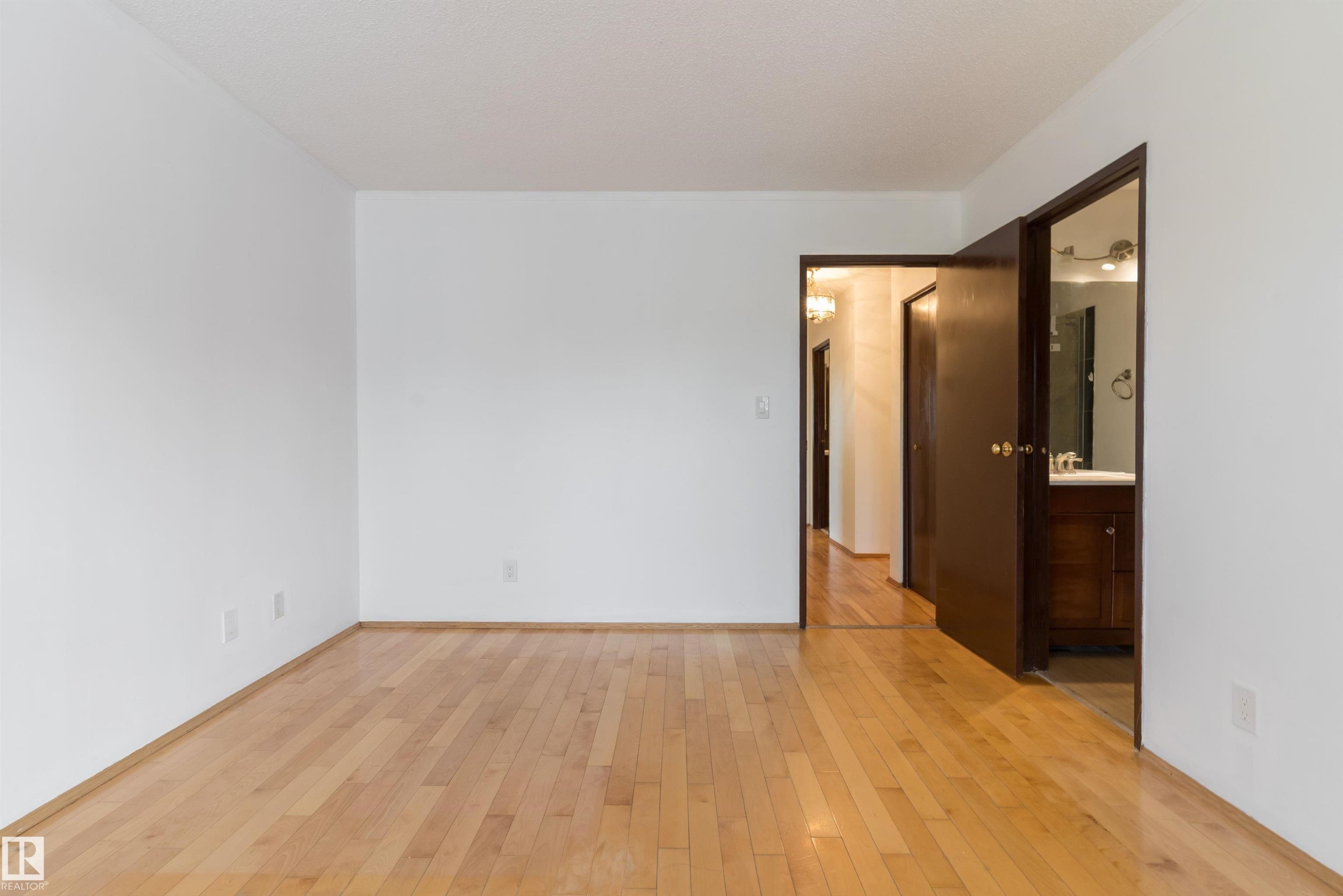 Hardwood flooring throughout, white painted walls, and dark wood-finish doors - 18739 72 Avenue Nw, Edmonton, AB