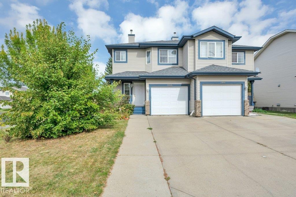 Two-story property featuring light-colored siding, contrasting blue trim, and single attached garage - 11448 169 Avenue Nw, Edmonton, AB