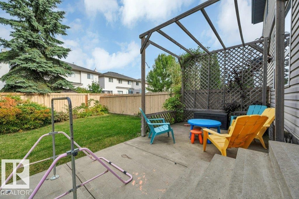 Concrete patio featuring a wood pergola and lattice privacy screen - 11448 169 Avenue Nw, Edmonton, AB