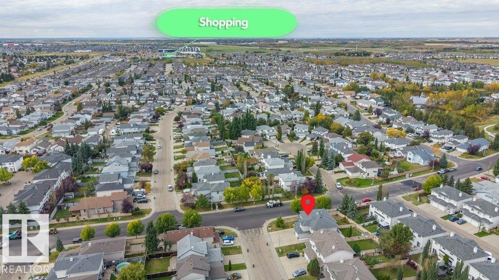 Aerial perspective showcasing a residential neighborhood with detached homes, mature trees, and paved streets - 11448 169 Avenue Nw, Edmonton, AB