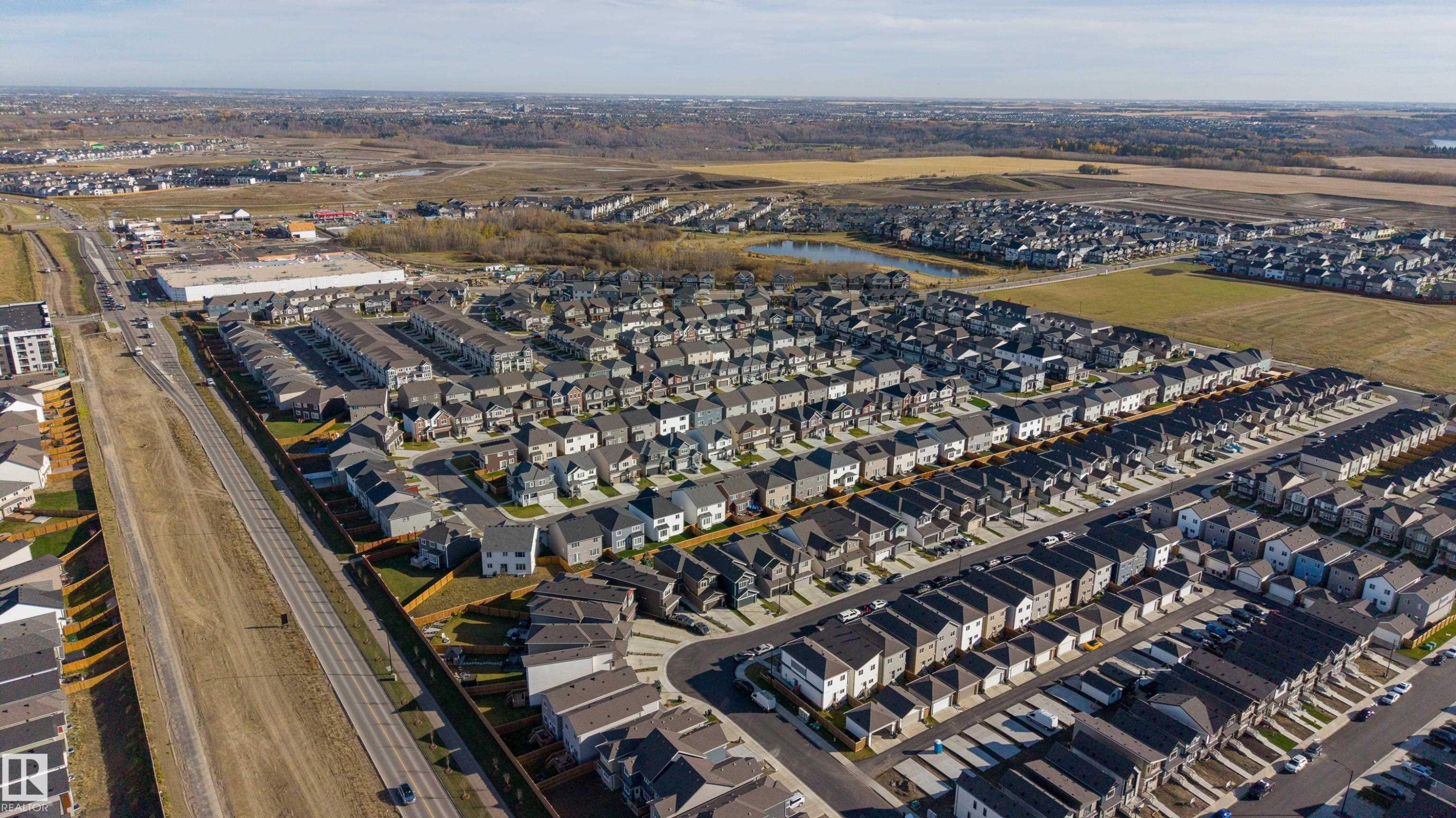 Aerial perspective of a planned residential development featuring organized street grids, paved thoroughfares, and proximity to expansive open land - 2045 209A St Nw, Edmonton, AB