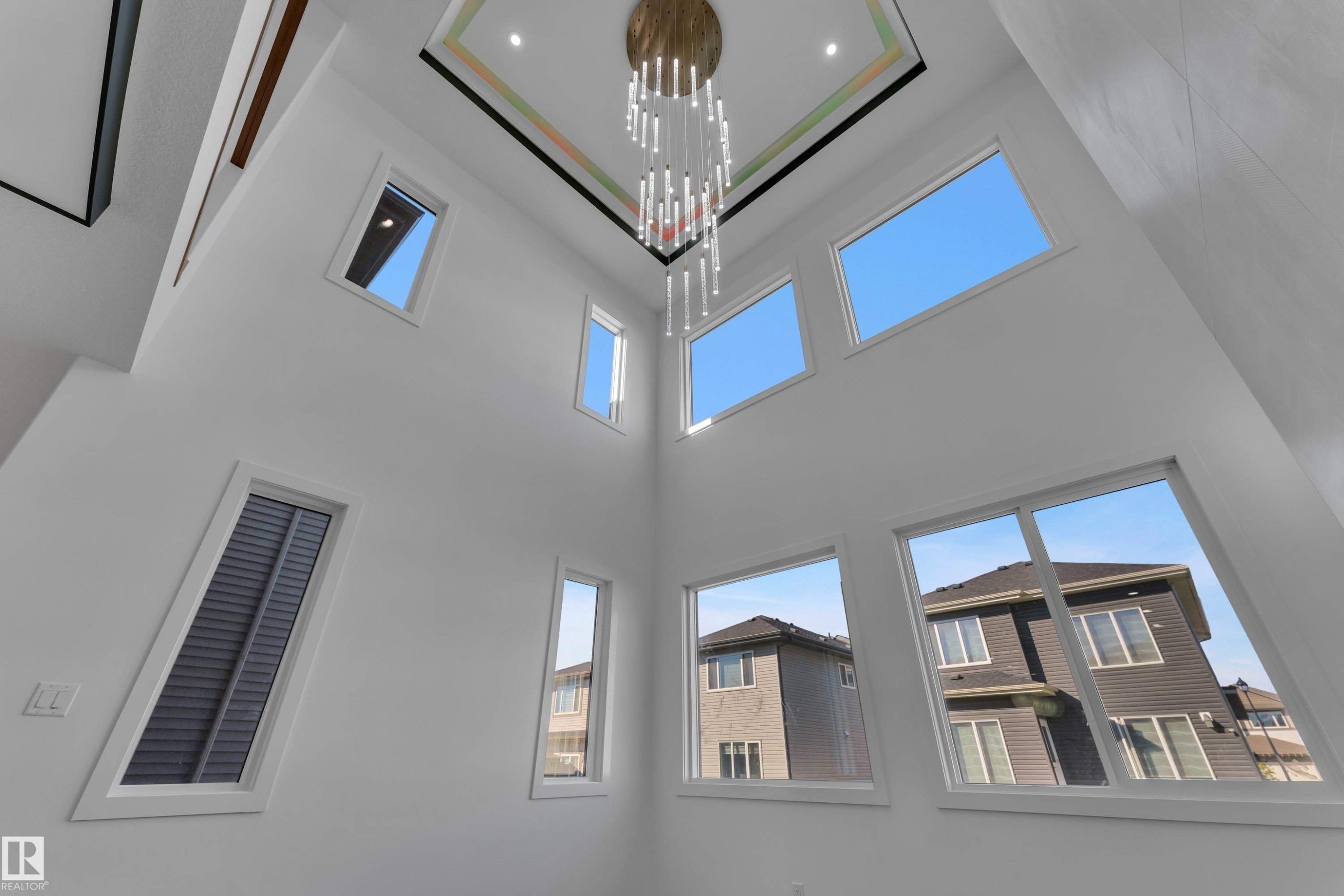 Vaulted ceiling featuring a decorative chandelier, multiple fixed windows, and window blinds - 3604 44 Avenue, Beaumont, AB
