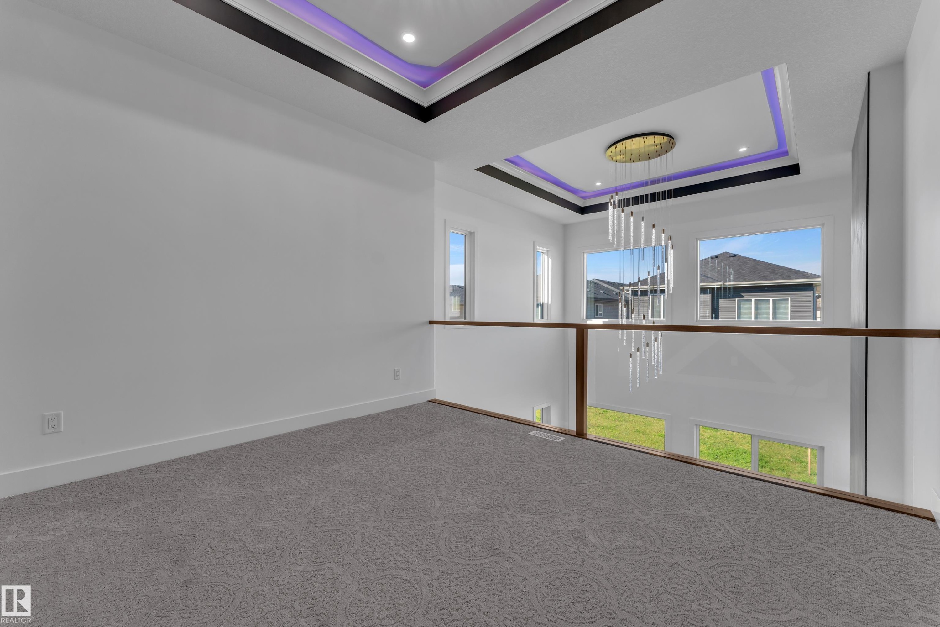 Upper-level landing with gray patterned carpeting and a glass railing - 3604 44 Avenue, Beaumont, AB