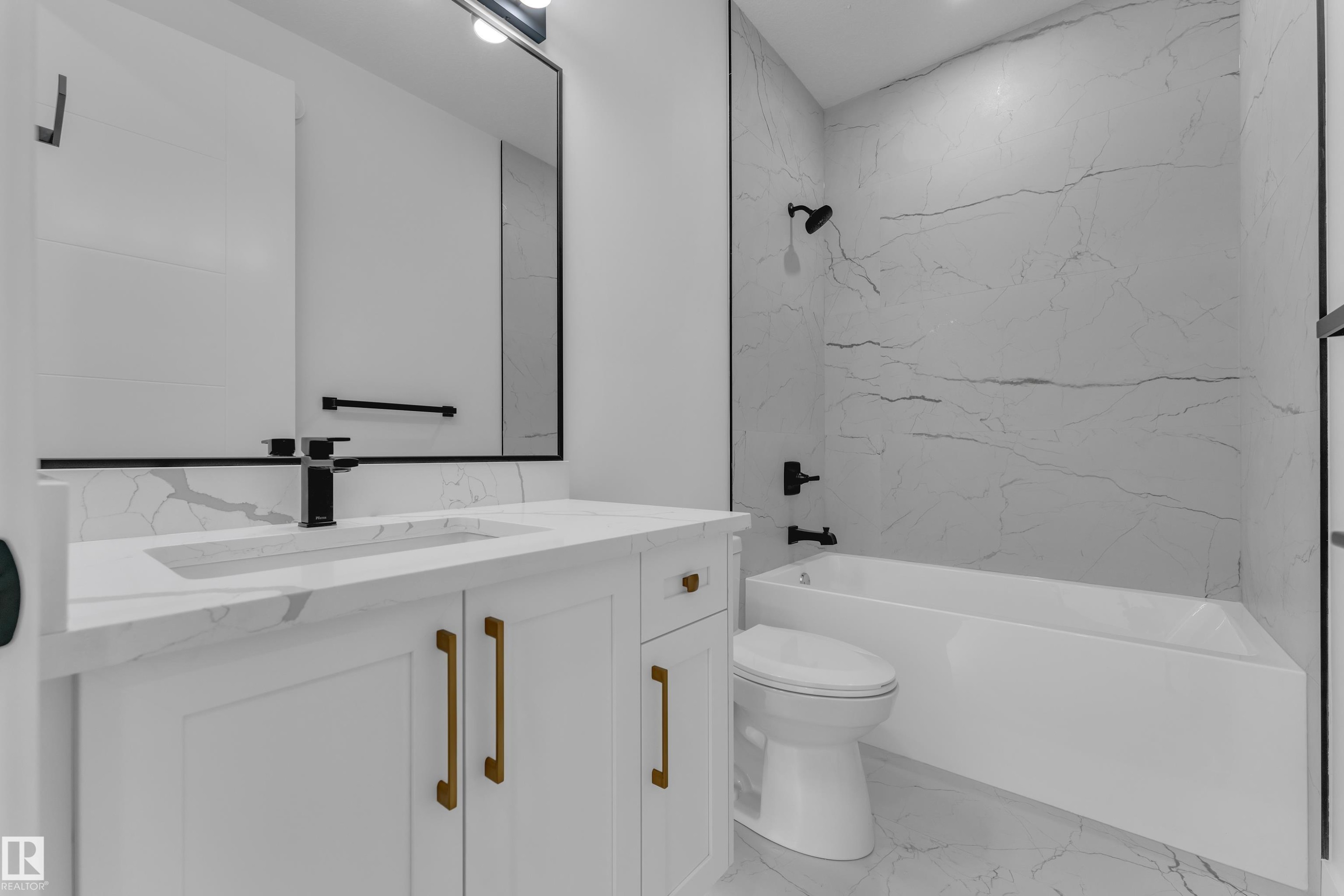 White vanity with gold-tone hardware, rectangular undermount sink, and black faucet - 3604 44 Avenue, Beaumont, AB