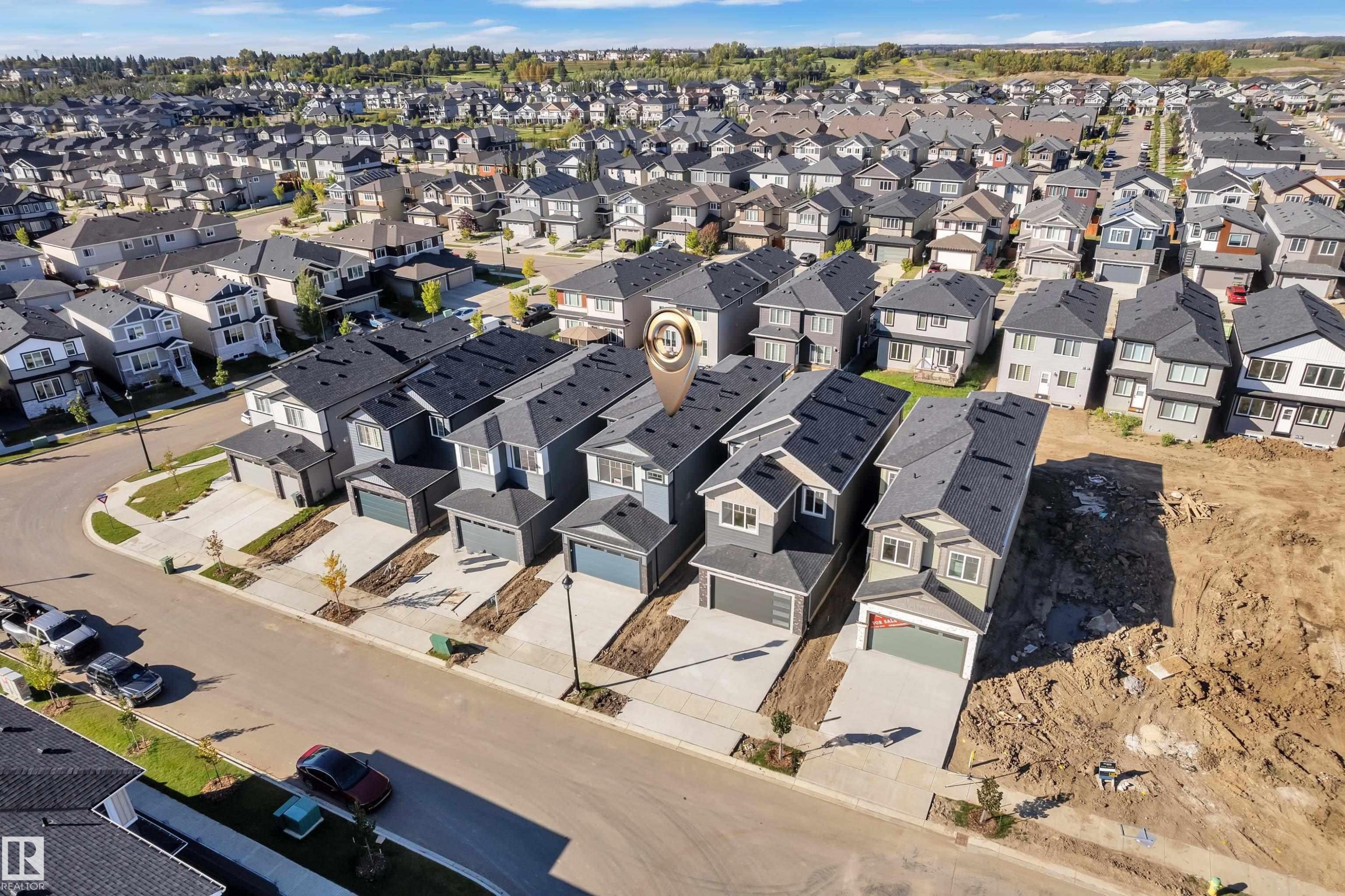 Newly constructed homes featuring attached garages, paved driveways, and modern exterior finishes - 3604 44 Avenue, Beaumont, AB