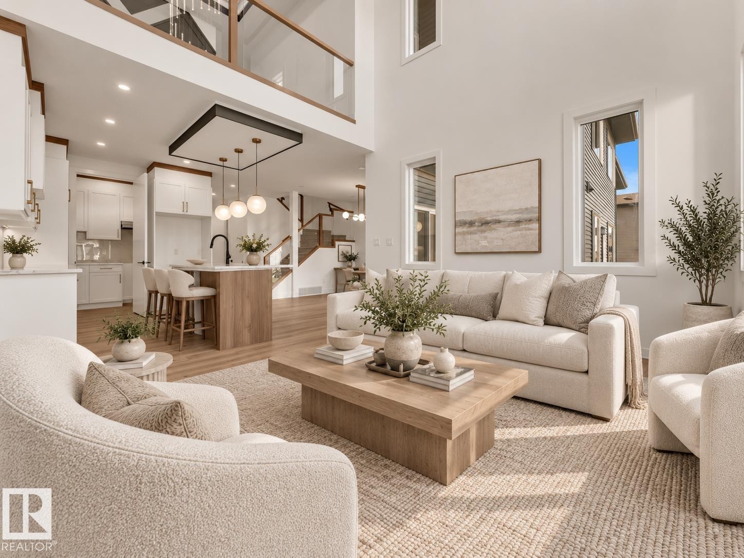 Open-concept living space featuring high ceilings, wood-finish flooring, a kitchen island with seating, and a second-story interior balcony - 3604 44 Avenue, Beaumont, AB