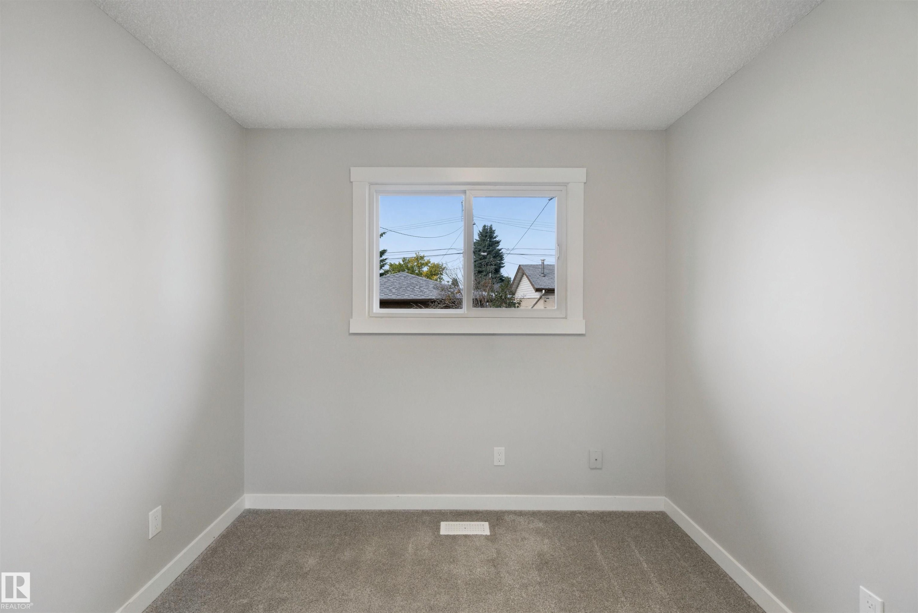 Neutral wall color, window with white trim, and gray carpet - 13212 73 Street Nw, Edmonton, AB