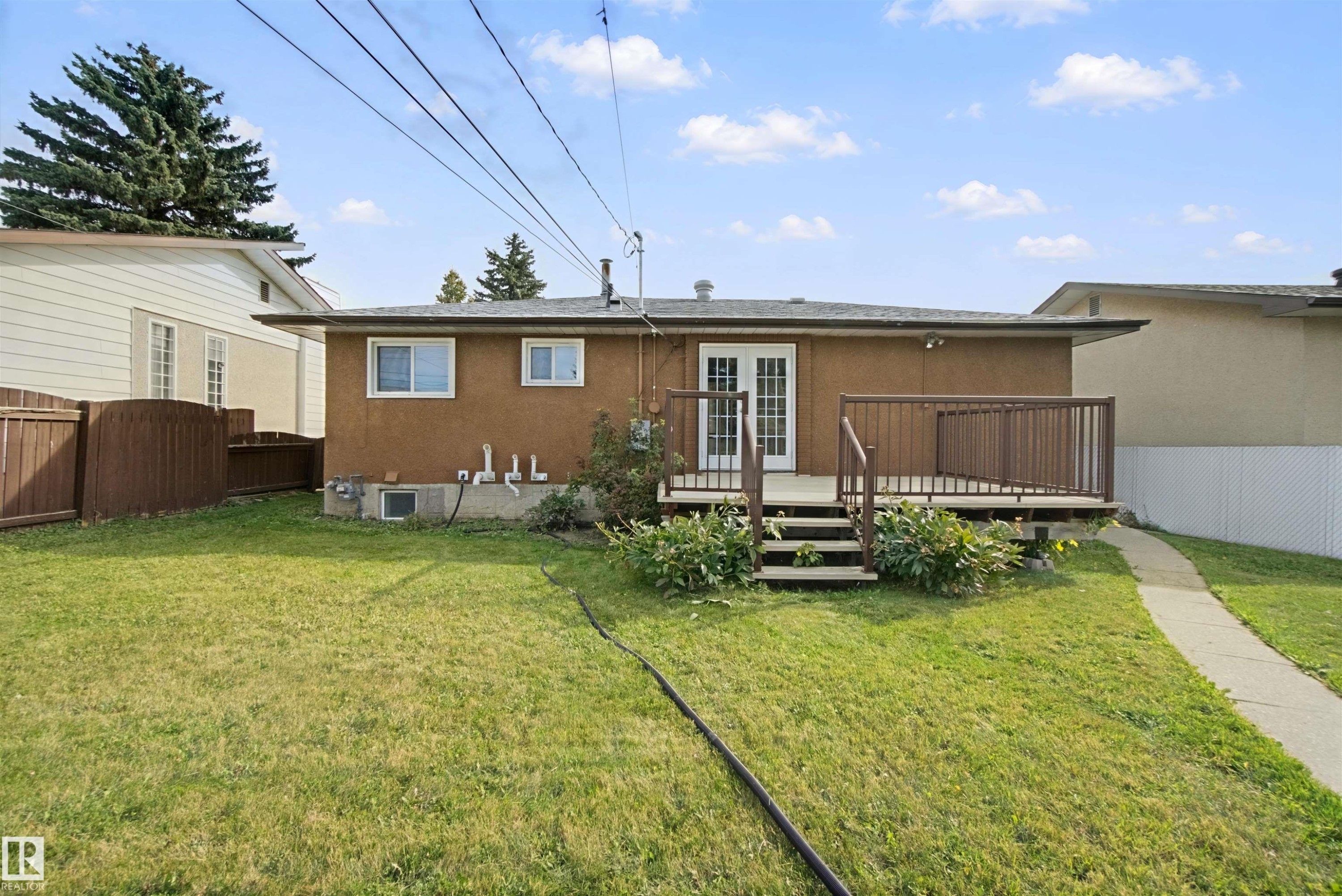 Expansive backyard featuring a manicured lawn, established landscaping, and a privacy fence - 13212 73 Street Nw, Edmonton, AB