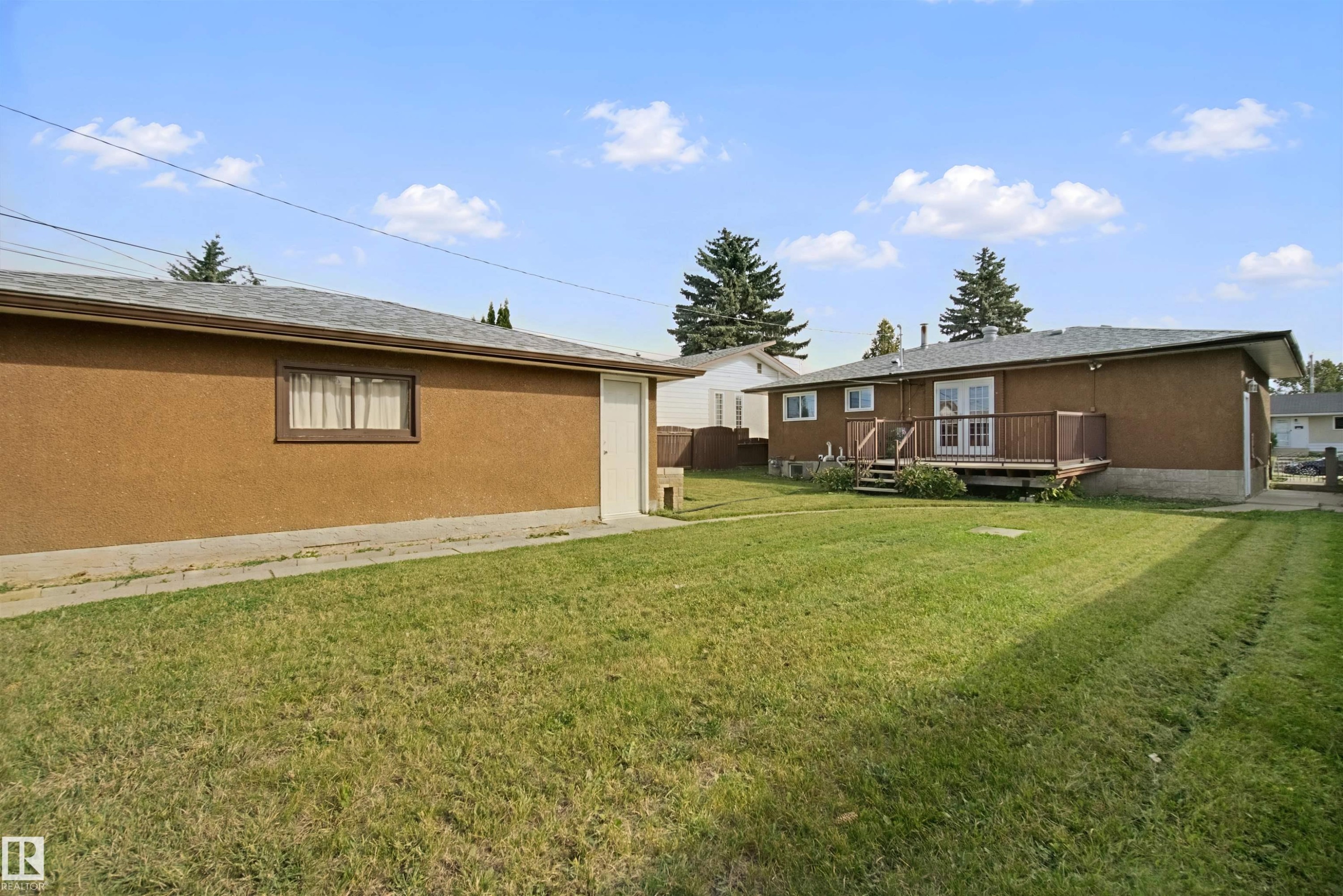 Expansive grassy yard with mature trees and a detached garage featuring a side entry - 13212 73 Street Nw, Edmonton, AB