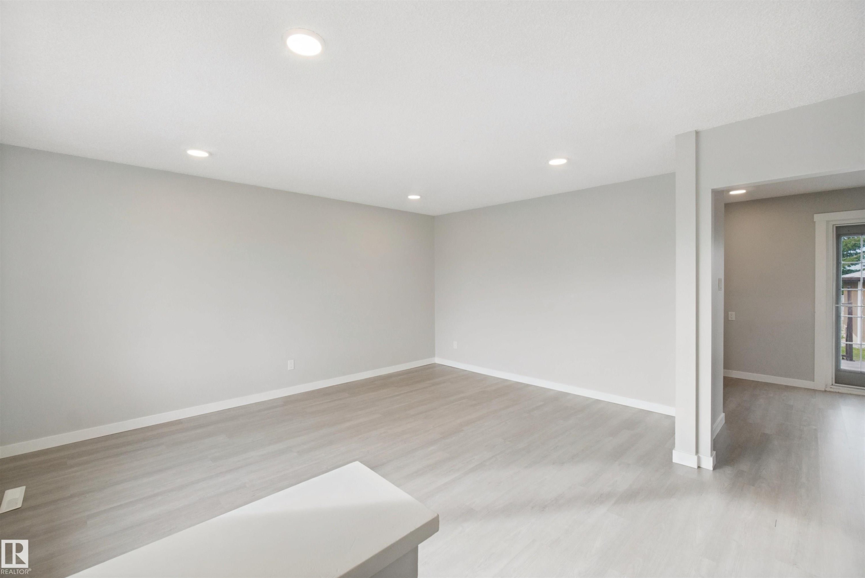 Recessed ceiling lighting, light gray wall finishes, wood-finish flooring, and white trim - 13212 73 Street Nw, Edmonton, AB