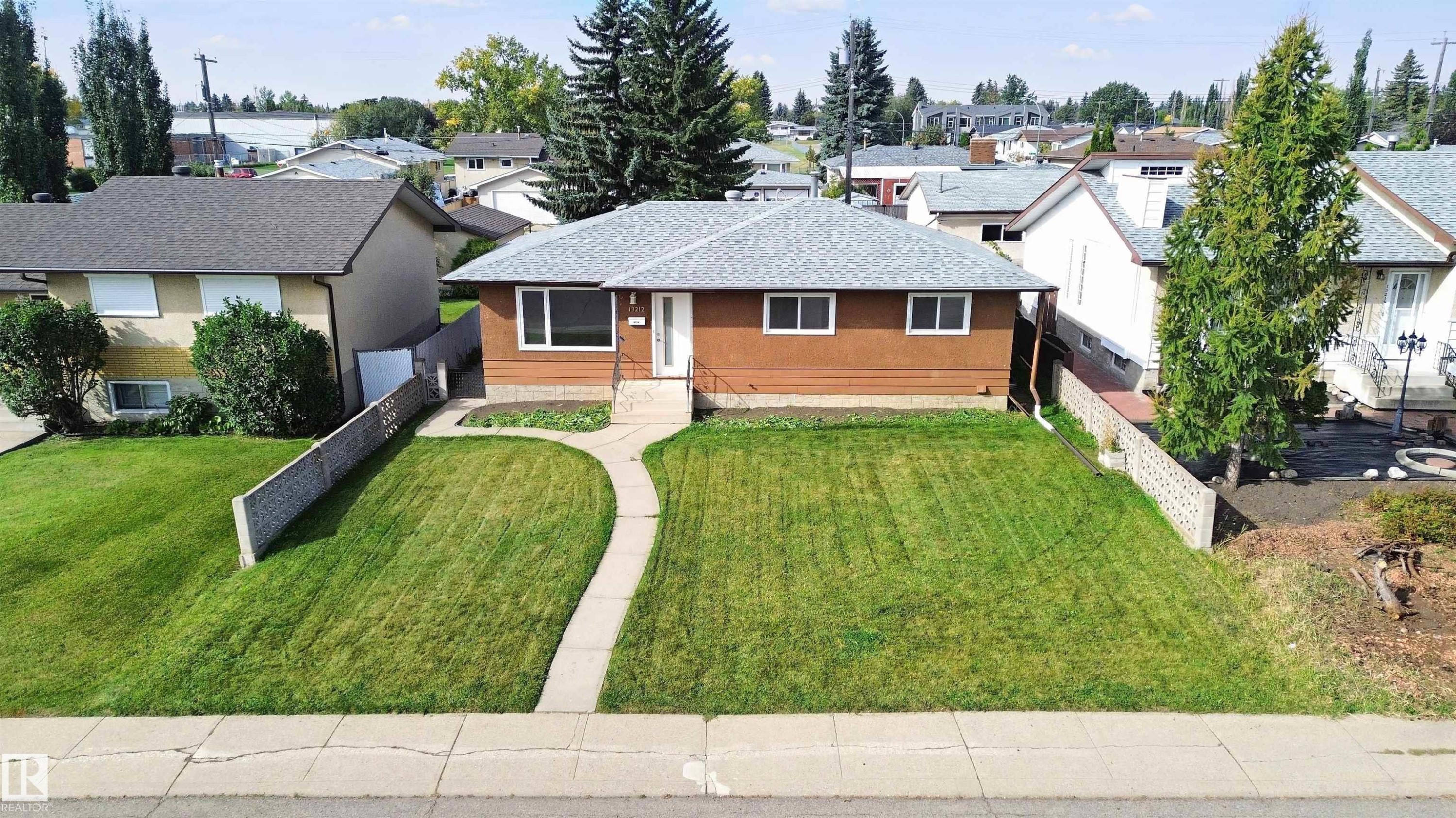 Pitched roof, light brown siding, white front door, concrete walkway, and manicured front lawn - 13212 73 Street Nw, Edmonton, AB