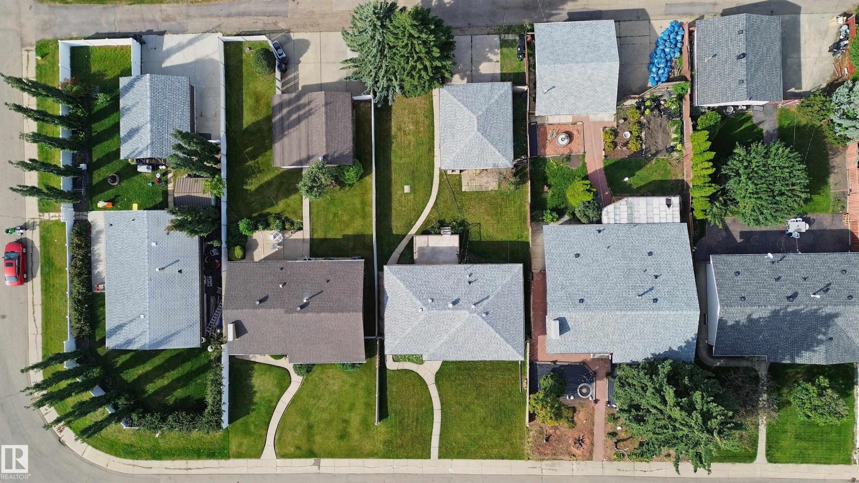 Residential property featuring a shingle roof and green landscaping - 13212 73 Street Nw, Edmonton, AB