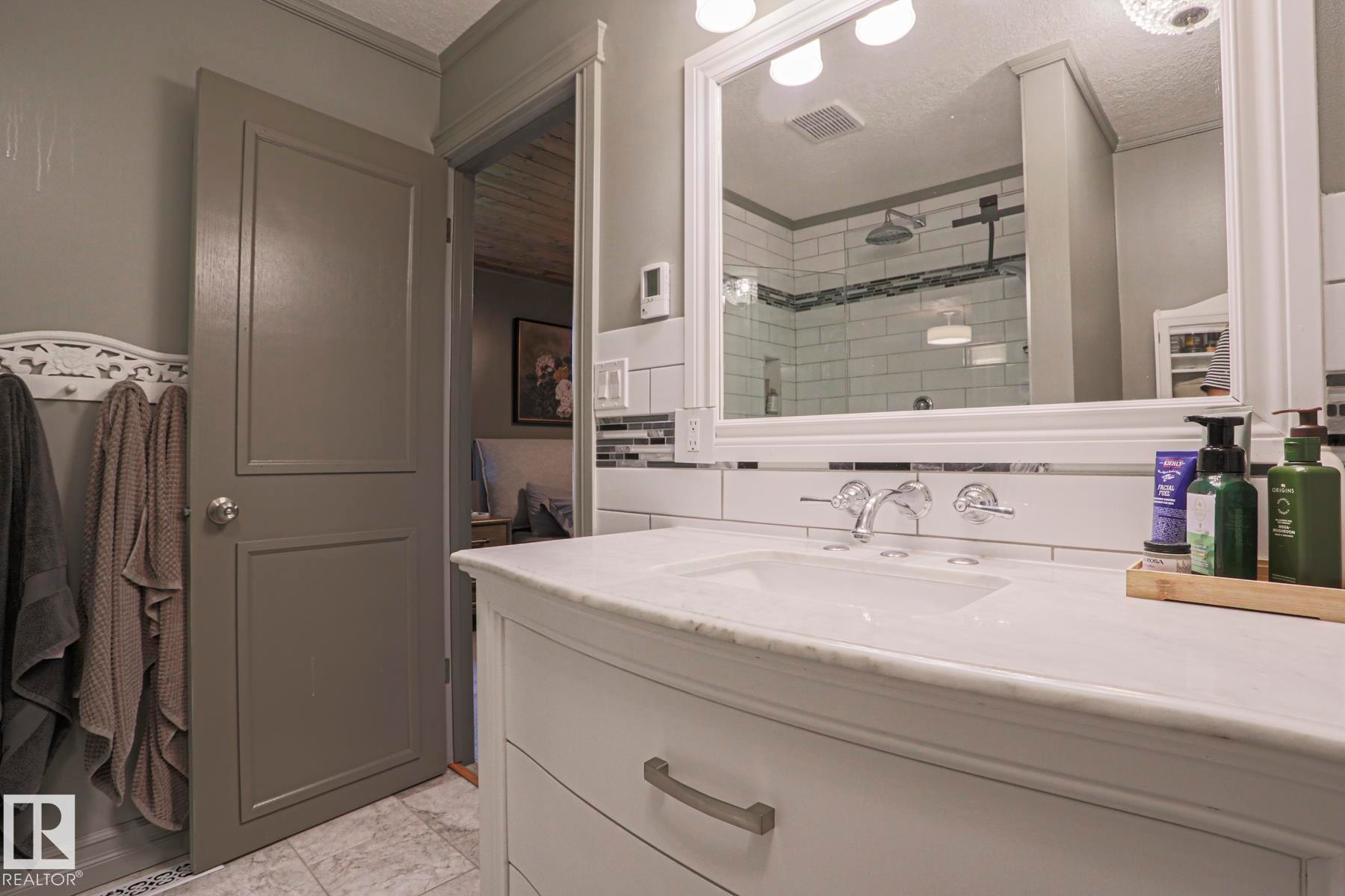 White vanity with chrome hardware, an undermount sink, and a white countertop - 2 Hillview Crescent, Sherwood Park, AB
