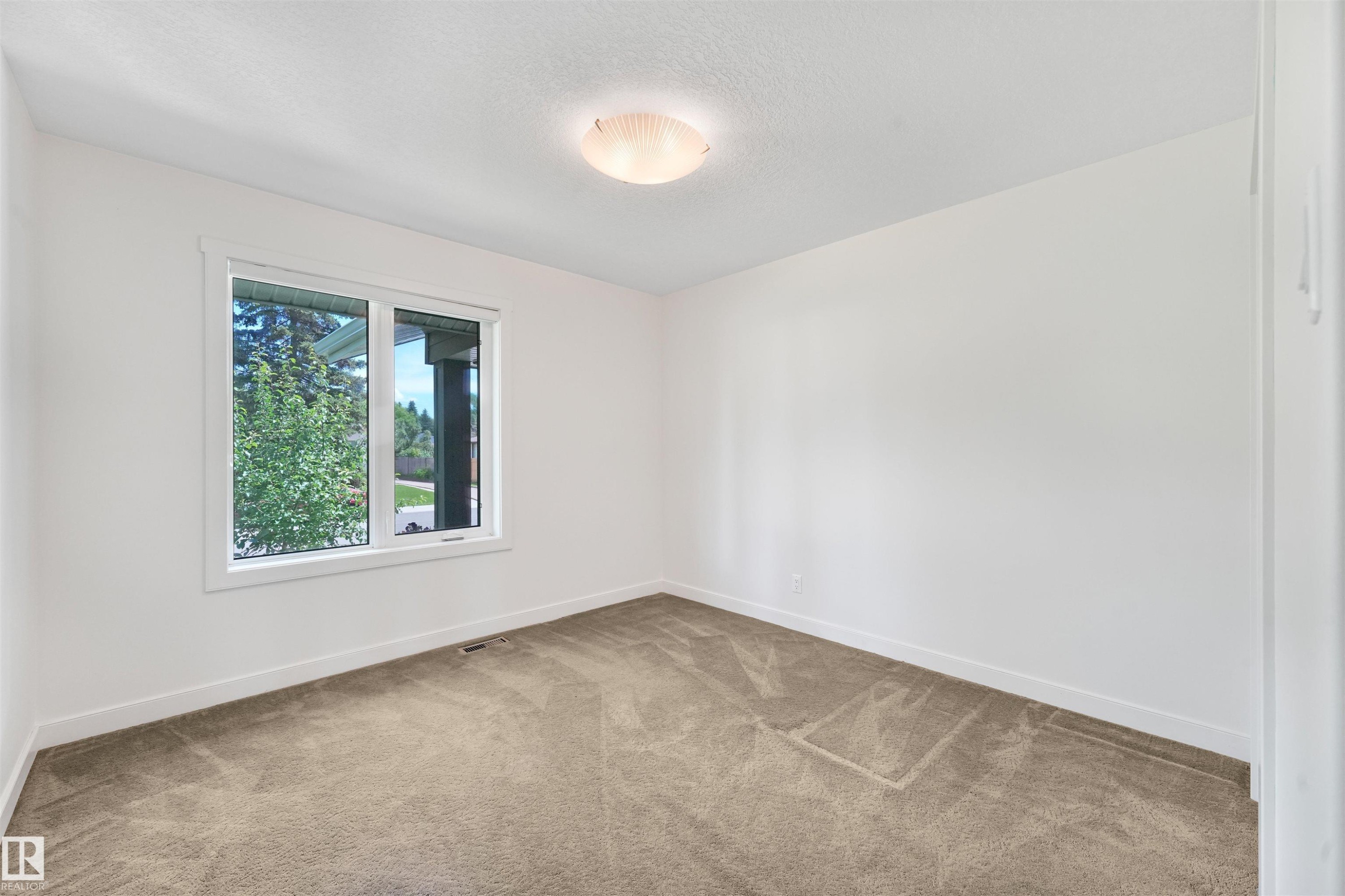 Neutral wall paint, plush carpet flooring, recessed window, and flush-mount ceiling light - 8212 148 Street Nw, Edmonton, AB